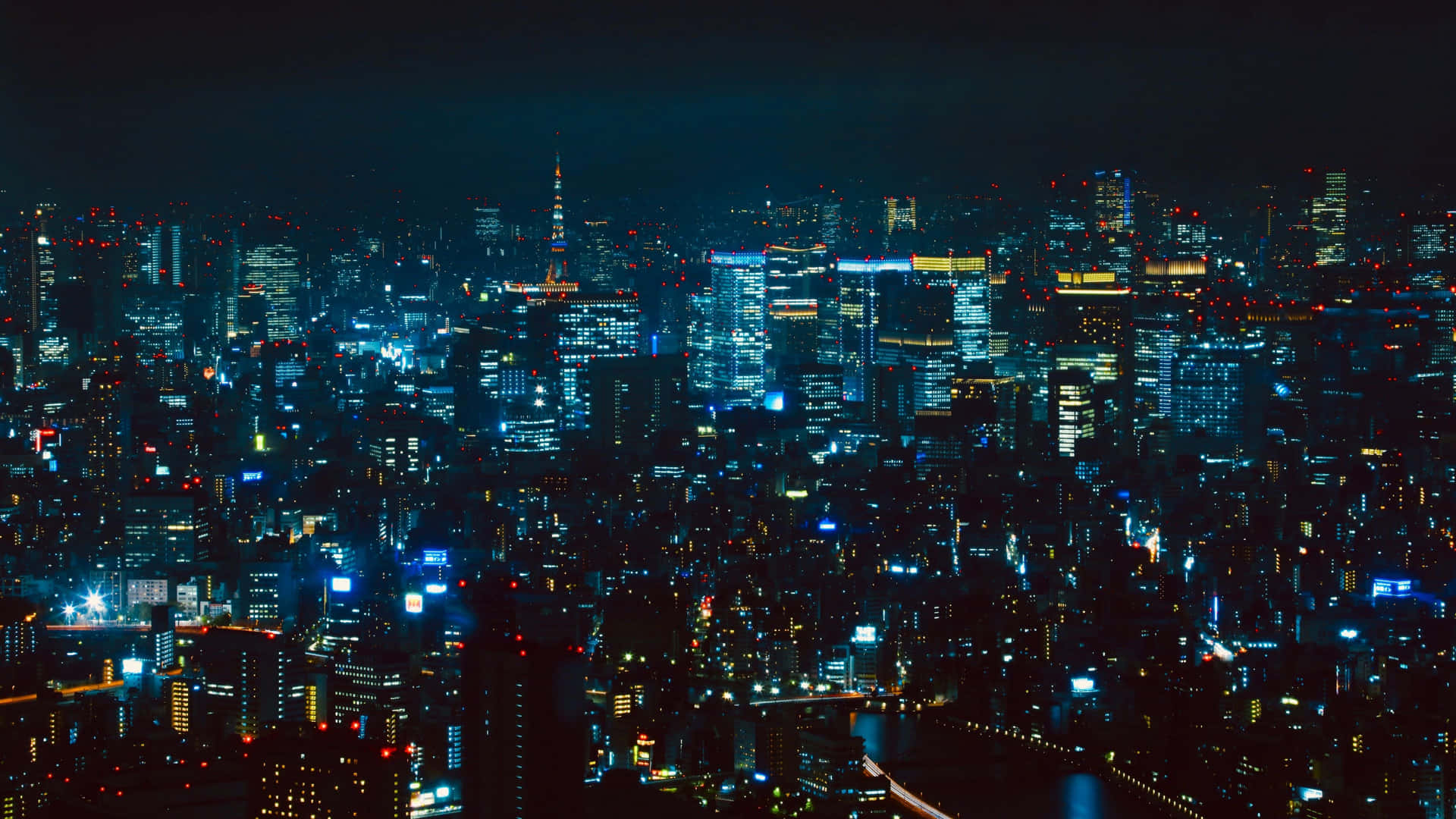東京城市夜景 壁紙 — 廣闊的城市夜景，無數發光的窗戶和霓虹燈照亮了高聳的摩天大樓，映襯著黑暗的天空。