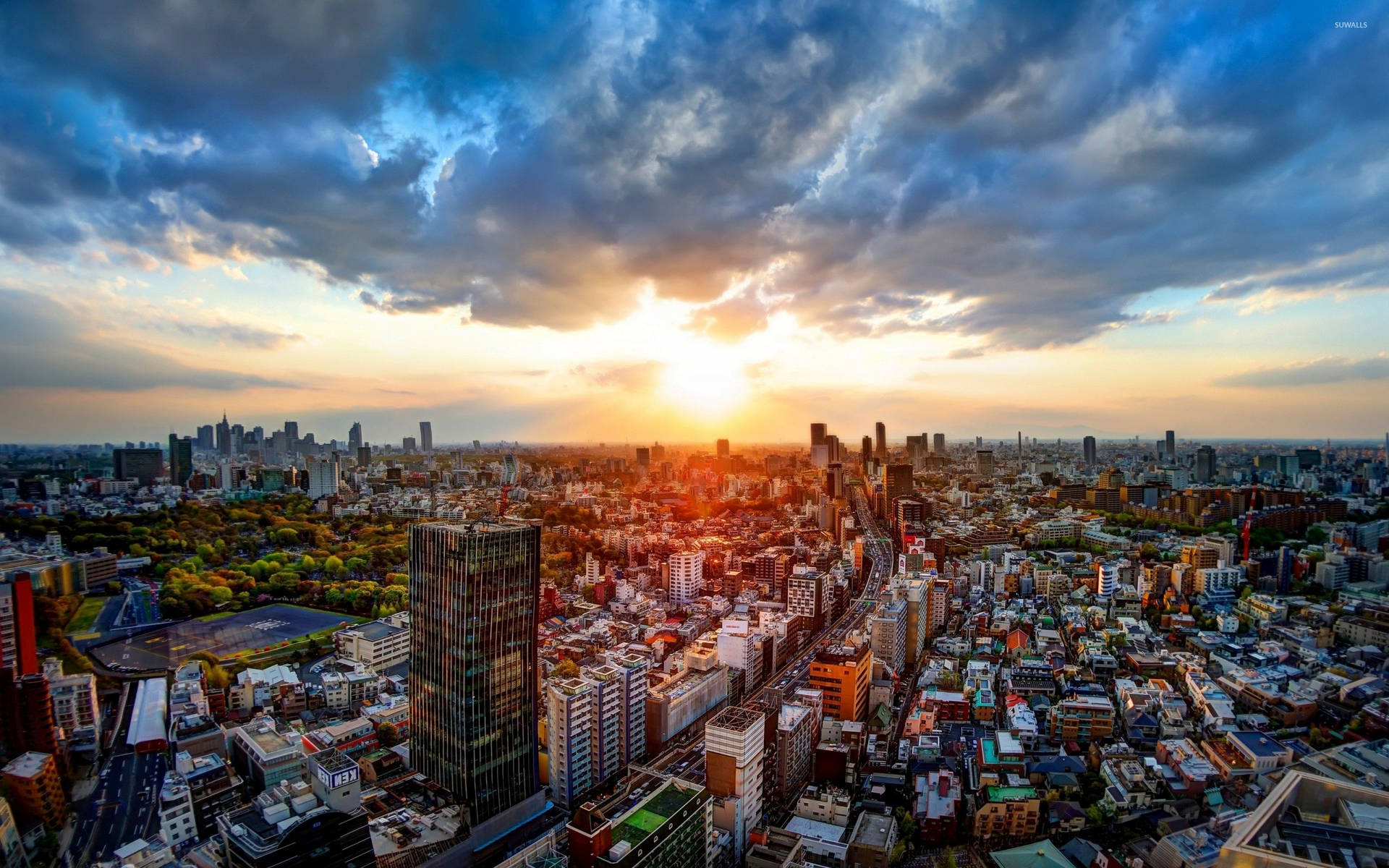 夕陽下，密集的城市景觀中摩天大樓和住宅建築在戲劇性的雲層下。