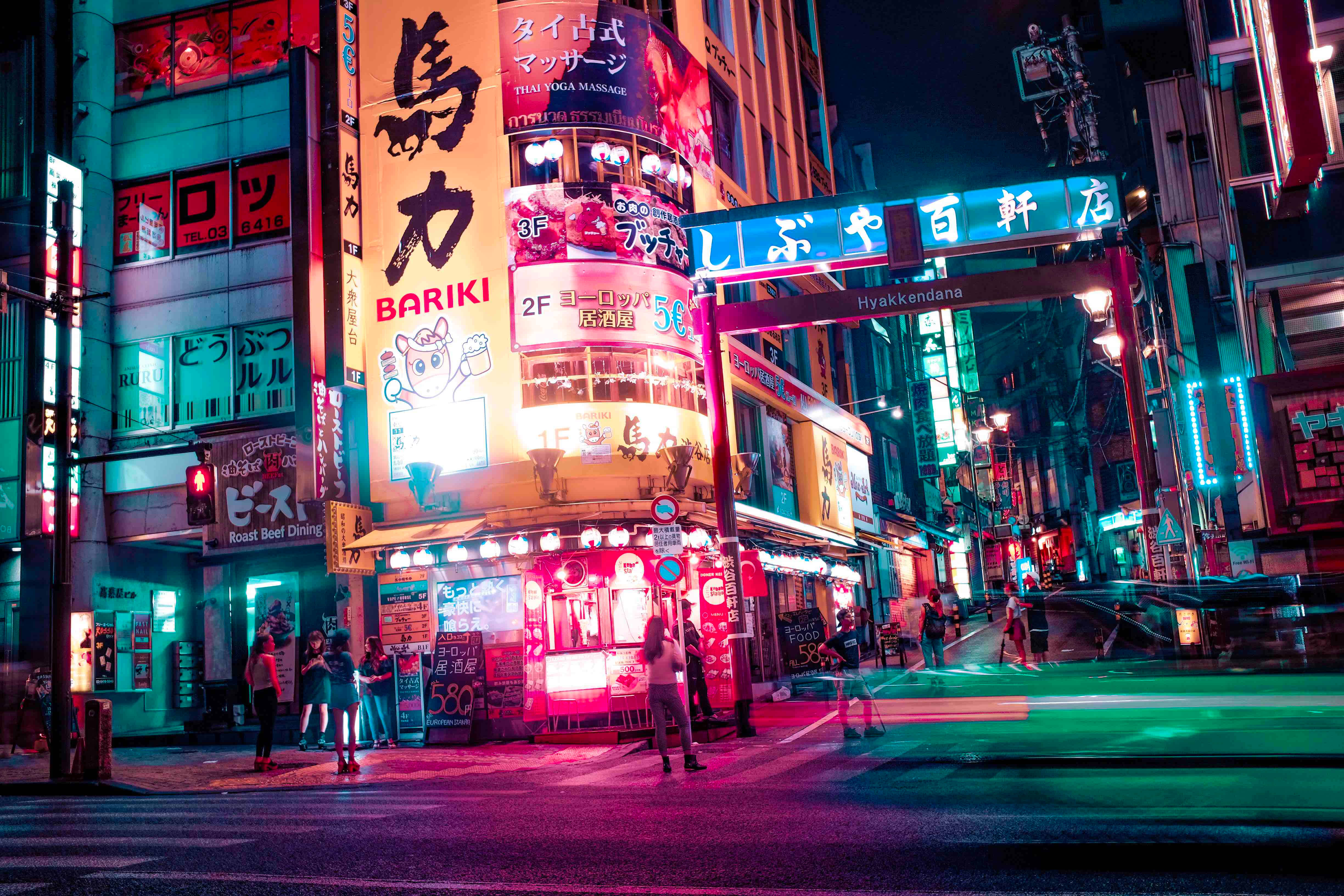 東京夜景，霓虹招牌點亮城市 壁紙 — 鮮豔的霓虹燈照亮了夜晚繁忙的東京街道，伴隨著過往車輛留下的光跡。