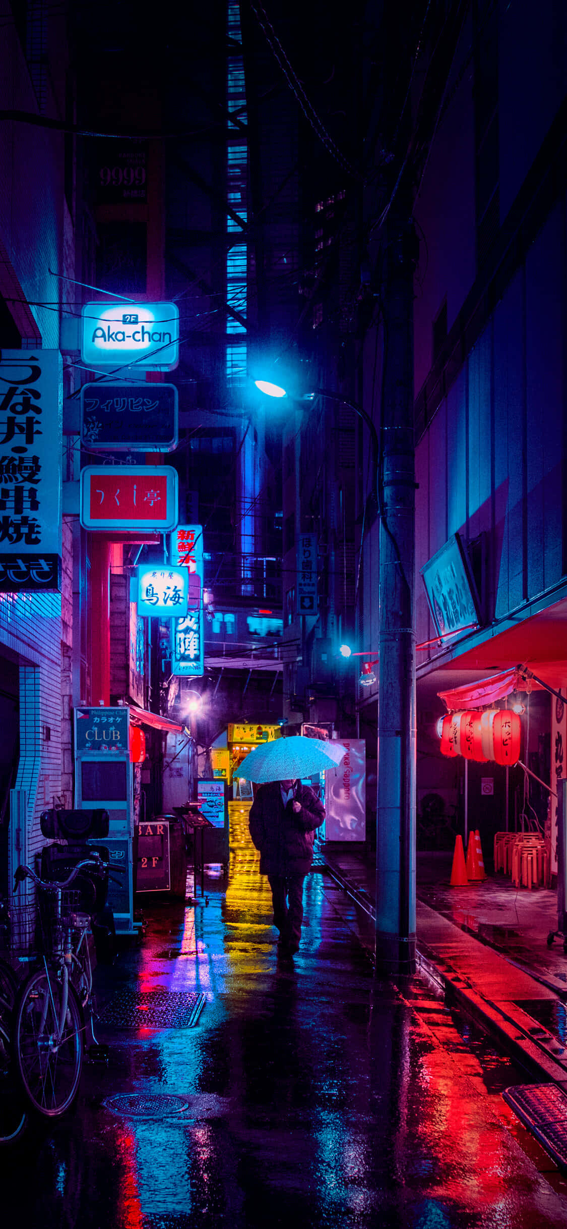 東京夜景手機壁紙 壁紙 — 一個孤獨的身影撐著傘，走在日本城市夜晚霓虹燈照亮、雨水浸濕的小巷中。