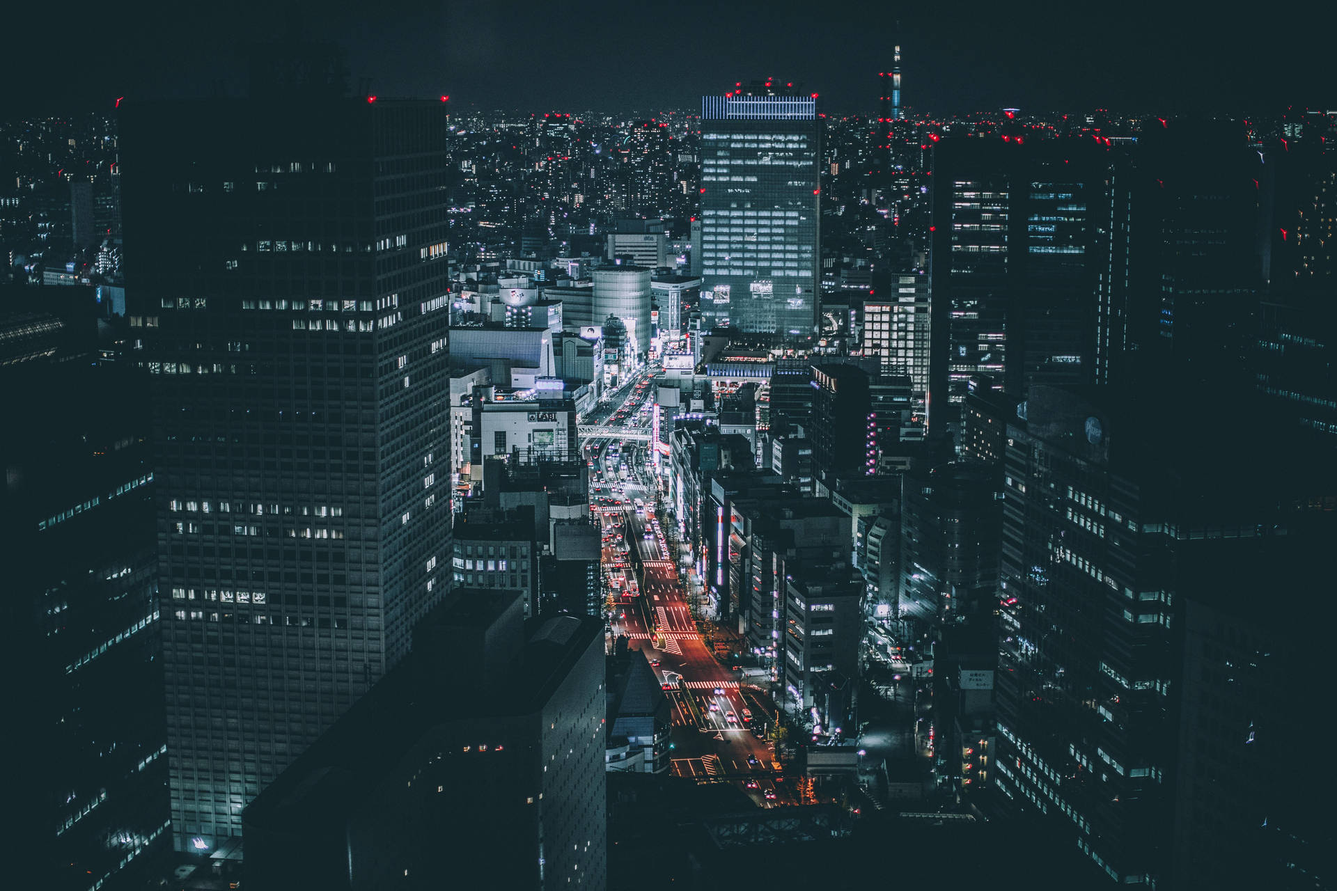 繁忙城市的夜間空中景觀，有明亮的摩天大樓和發光的街道。