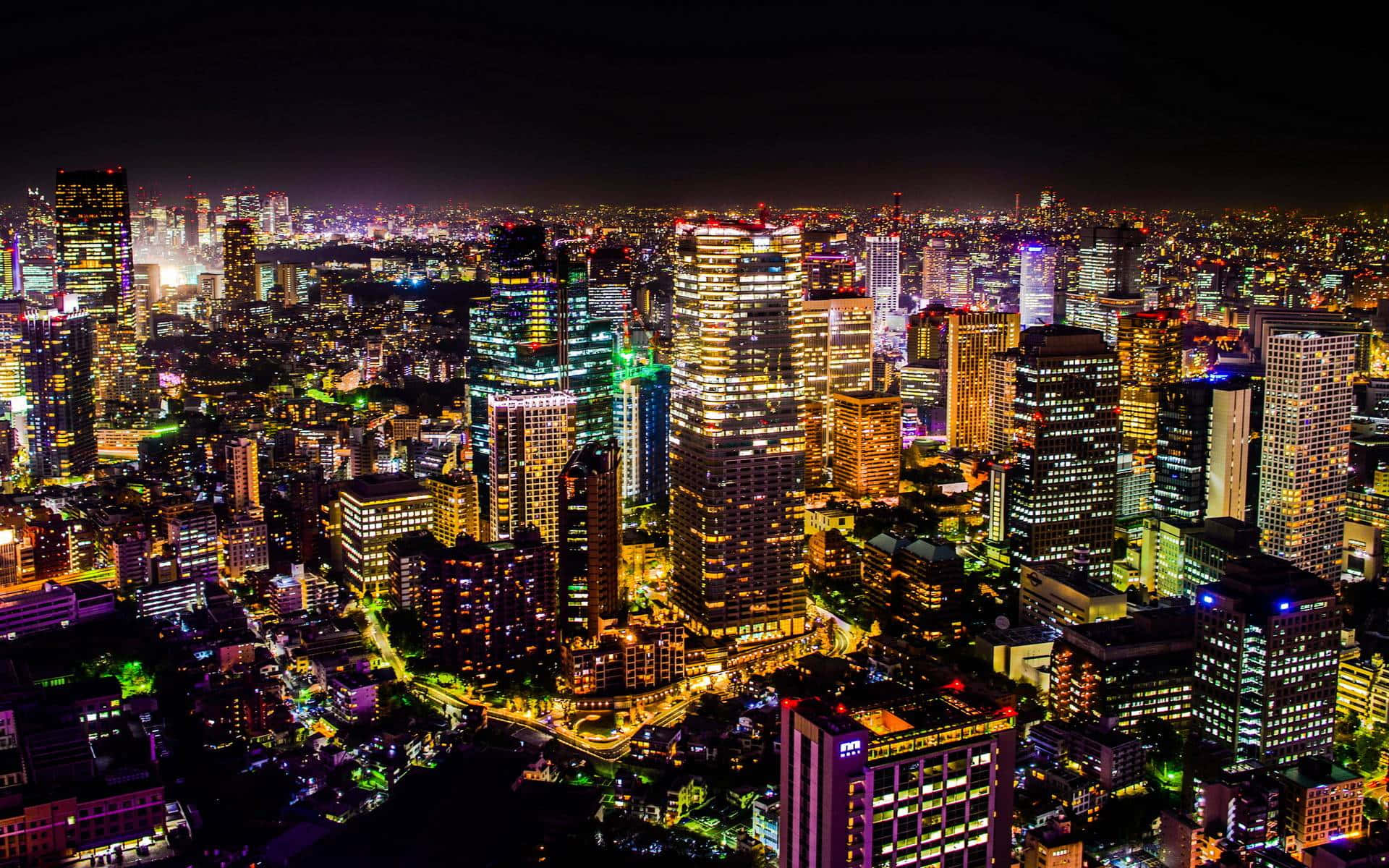 密集城市的夜間鳥瞰圖，摩天大樓和街道燈火通明。