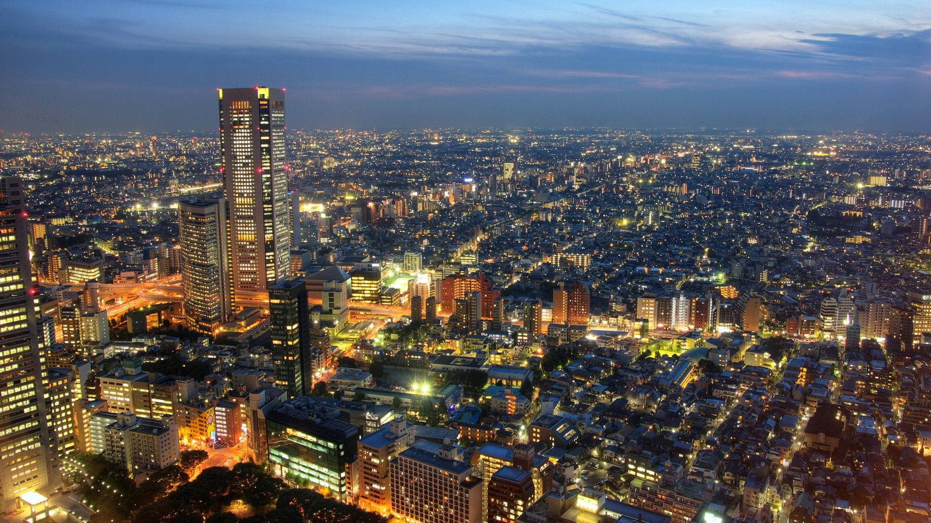 黃昏時分充滿活力的城市鳥瞰圖，建築物和街道燈火通明。