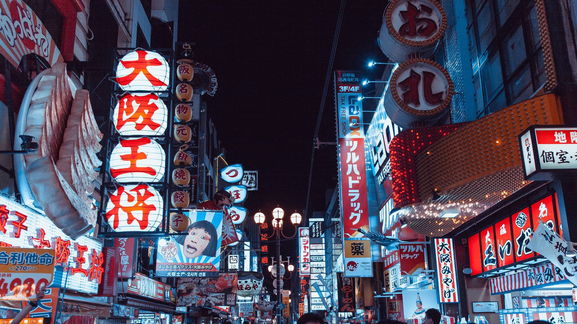 東京夜間閃耀的商店招牌 壁紙 — 充滿活力的霓虹燈照亮了繁華的東京夜晚街道，街道上佈滿了發光的廣告和擁擠的人行道。