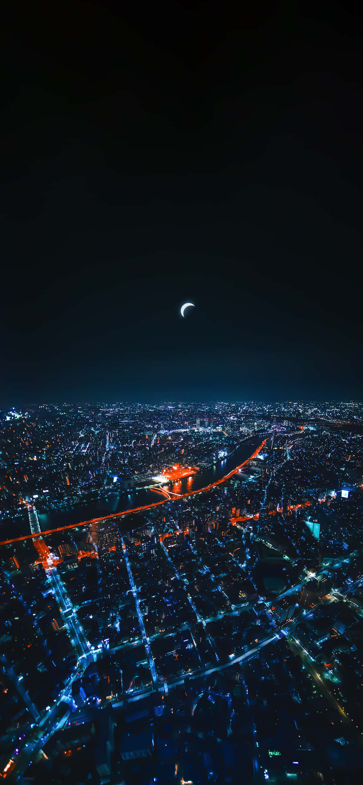 東京天空樹夜景 壁紙 — 新月下，一座廣闊城市在夜晚被藍色和橙色燈光照亮的鳥瞰圖。