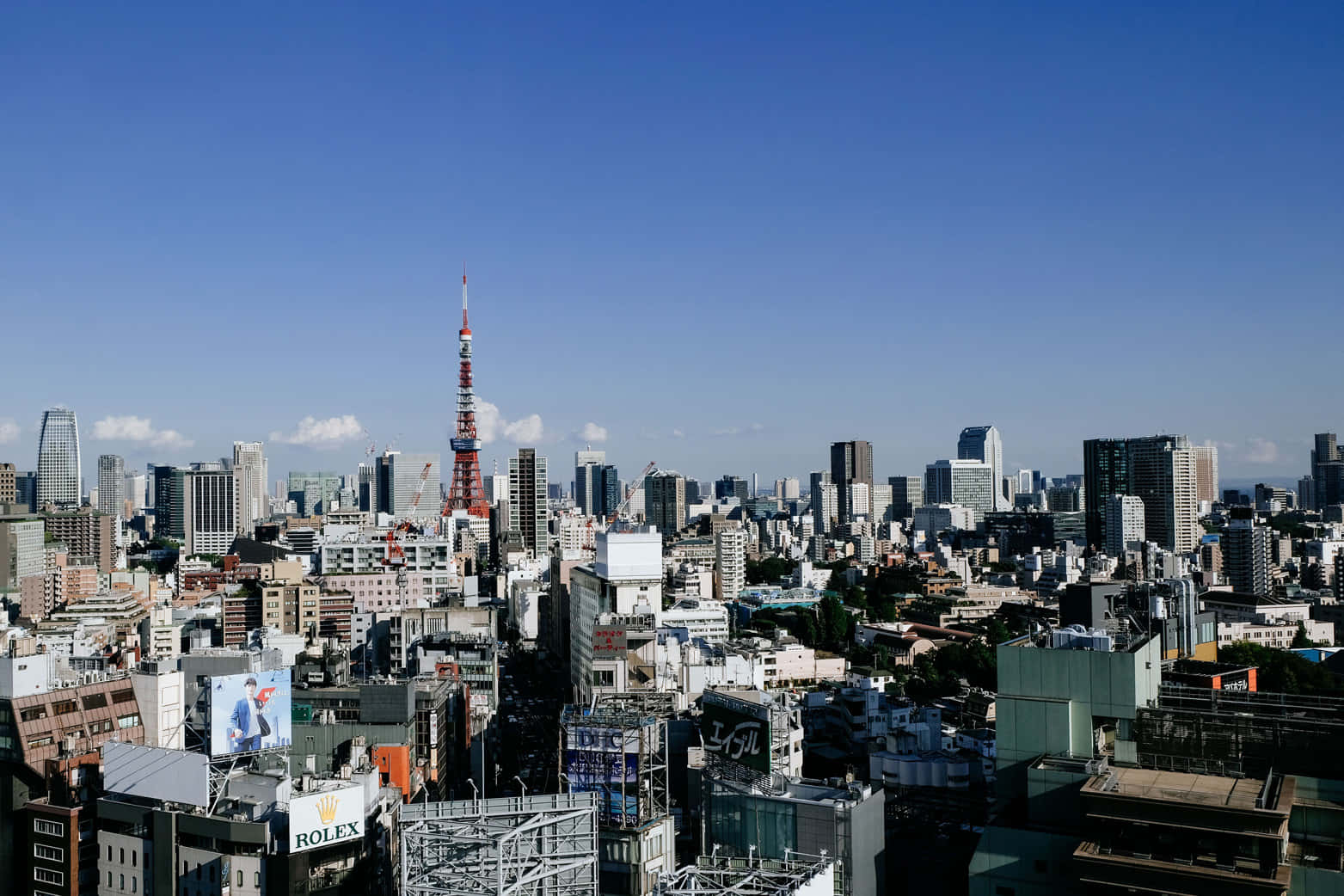 東京建築下午景觀背景 壁紙 — 在清澈藍天下，以標誌性紅白東京塔為主導的東京天際線全景。
