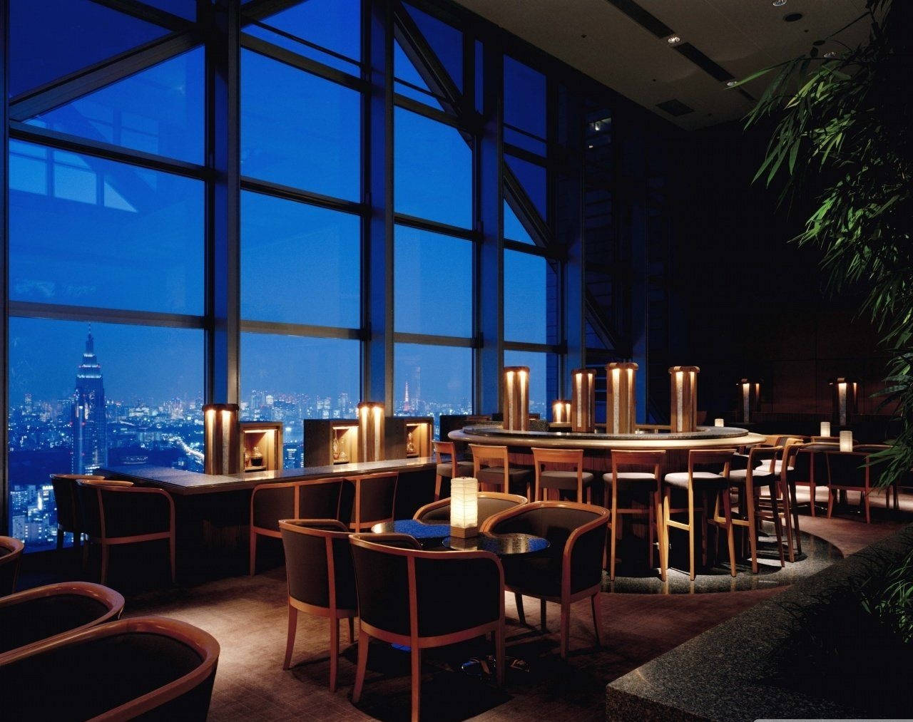 東京柏悅酒店餐廳 壁紙 — 豪華休息室，溫暖燭光餐桌透過落地窗俯瞰夜晚閃爍的城市天際線。