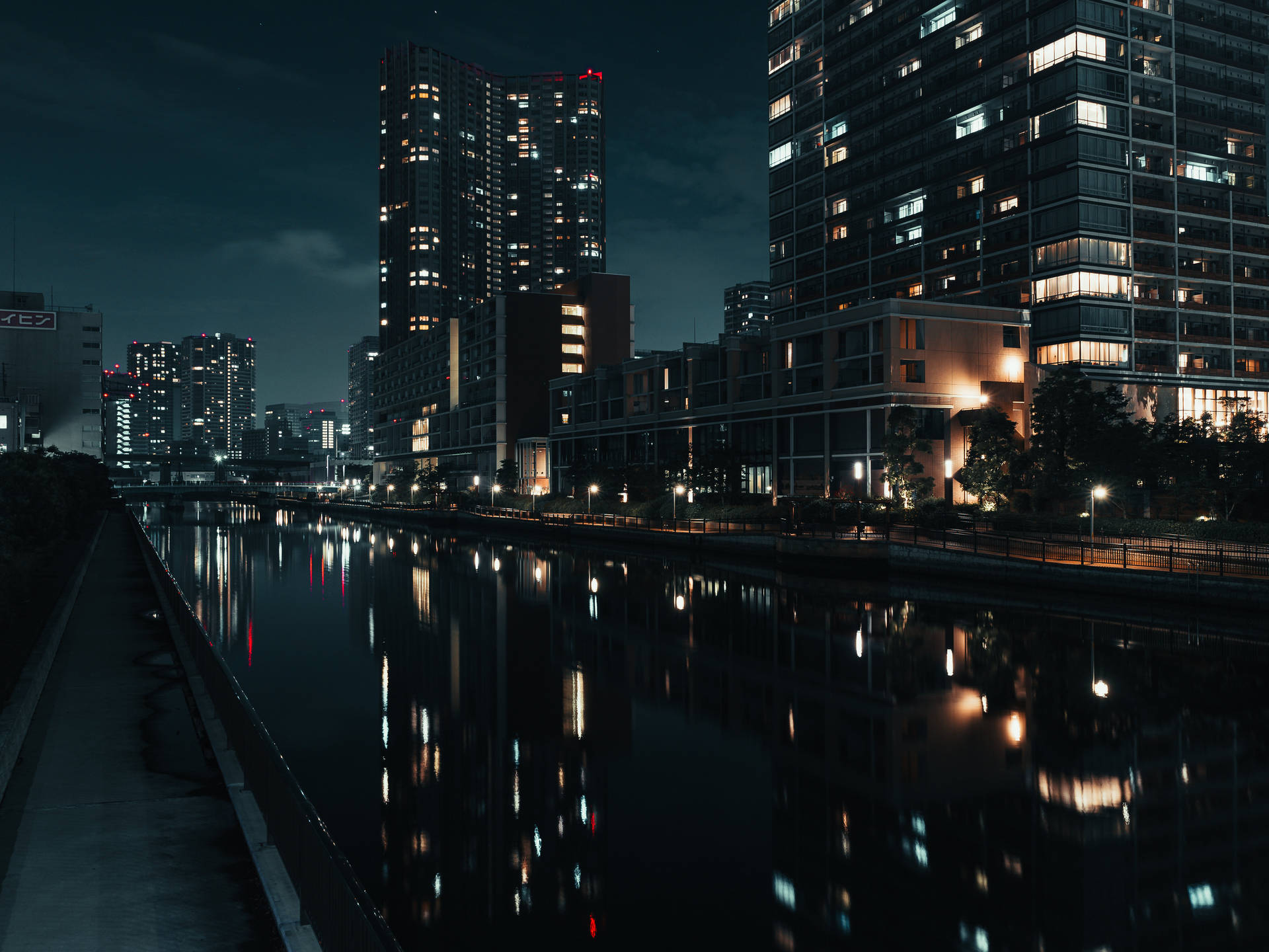 夜晚城市天際線倒映在平靜的河面上，窗戶閃爍著光芒。