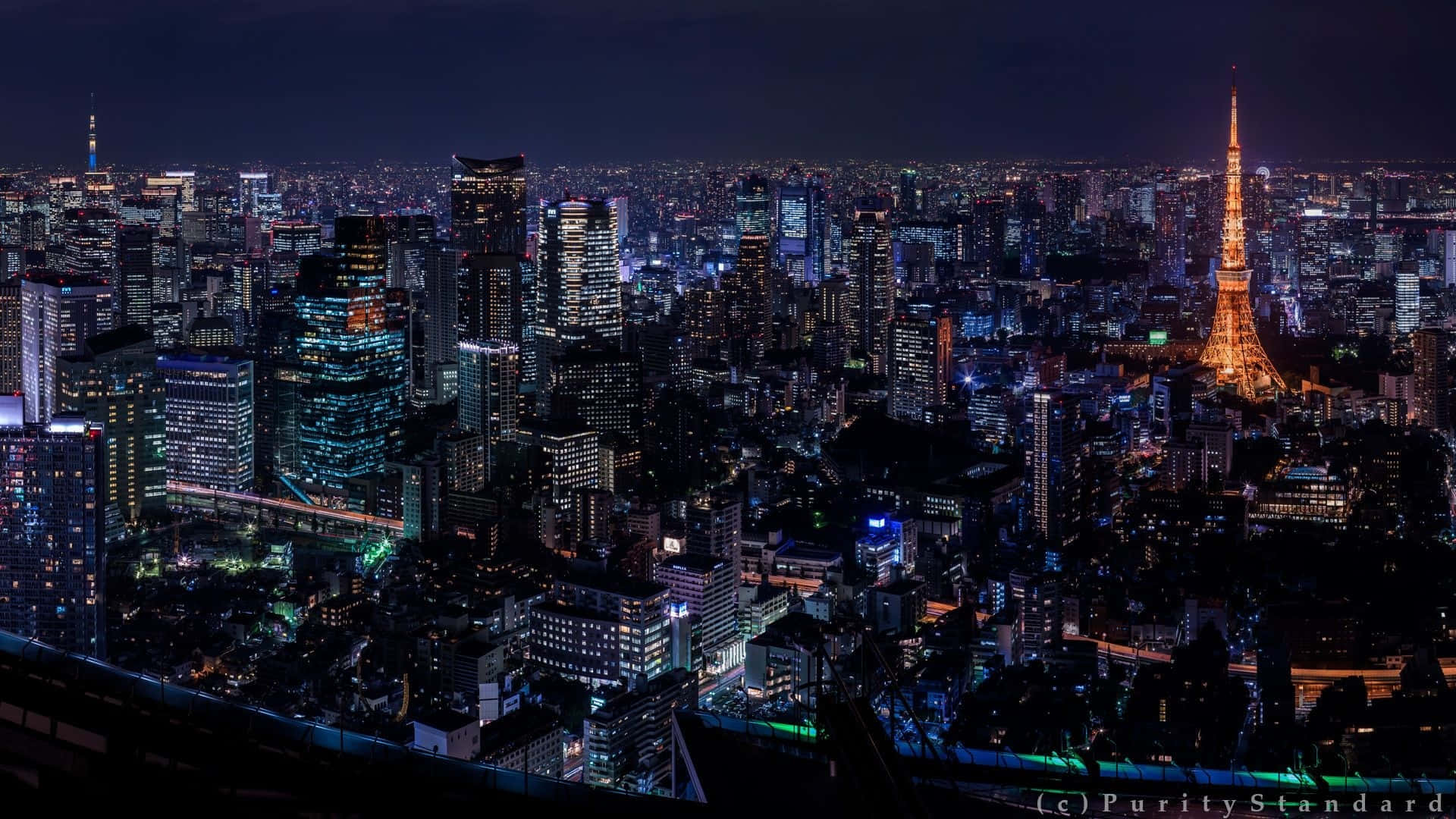 東京背景 未來感城市燈光效果 壁紙 — 東京天際線的迷人夜景全景，東京塔在閃爍的摩天大樓中熠熠生輝。