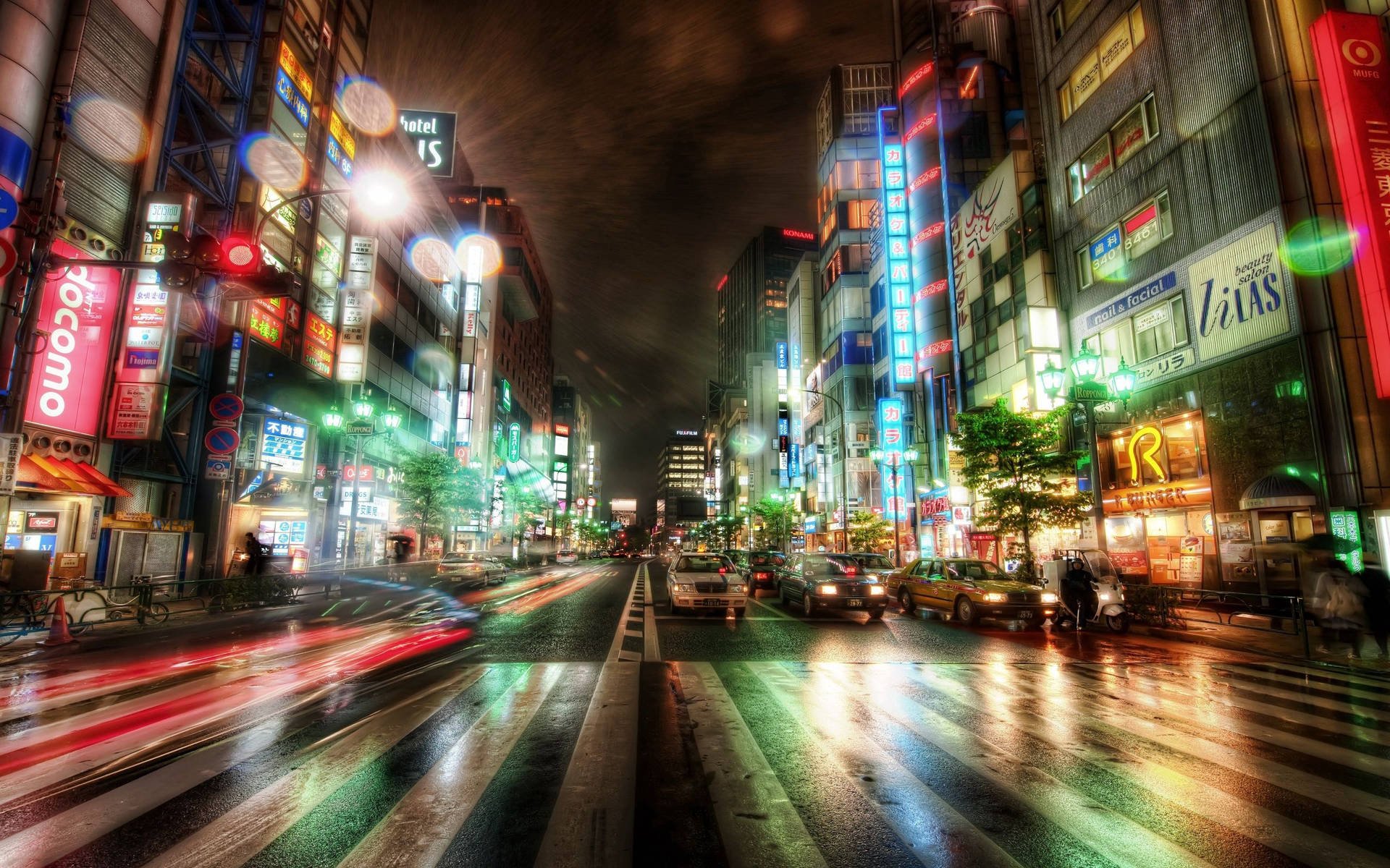 霓虹燈照亮了一條繁忙潮濕的城市街道夜景，帶有模糊的車燈。