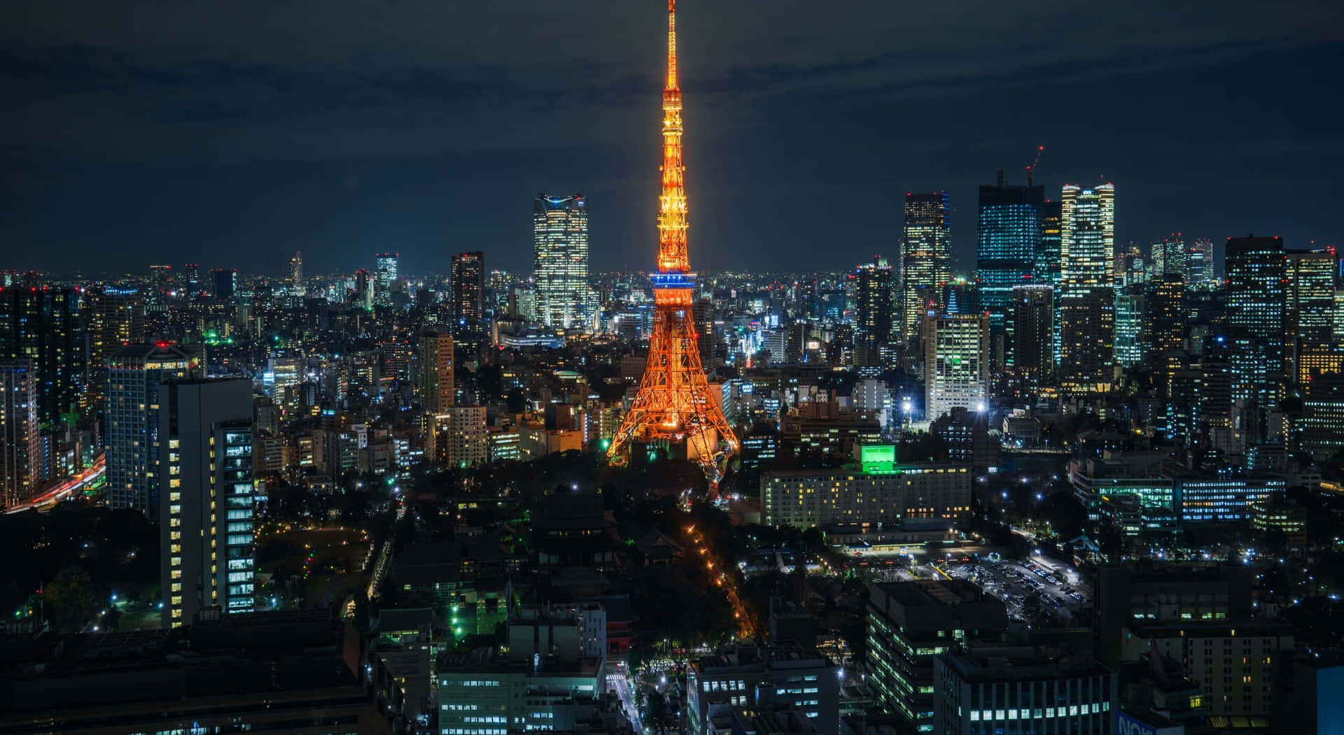 夜晚的東京鐵塔，周圍環繞著閃爍的城市燈光。