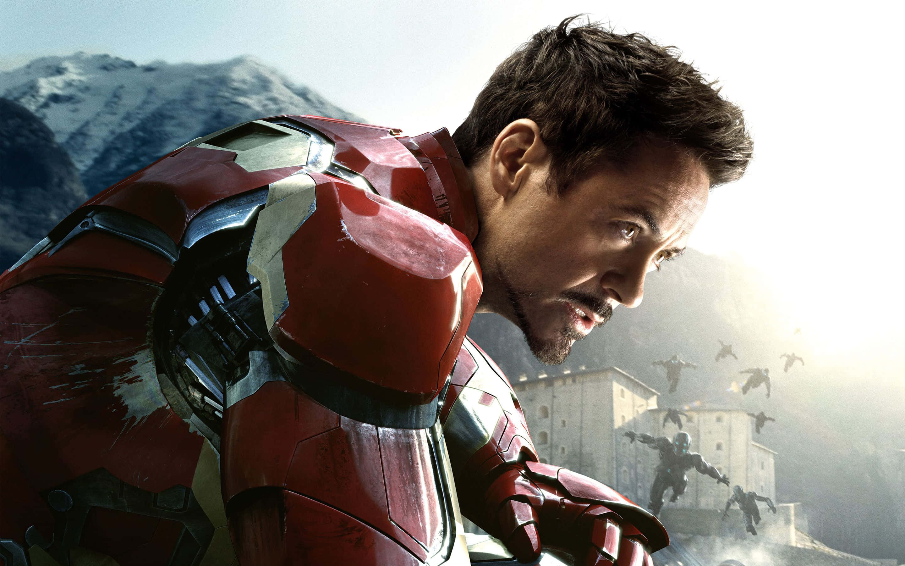Iron Man Movies 桌布 壁紙 — 東尼·史塔克穿著紅色鐵甲奇俠裝甲，在雪山背景下對抗飛行的敵人，神情堅定。