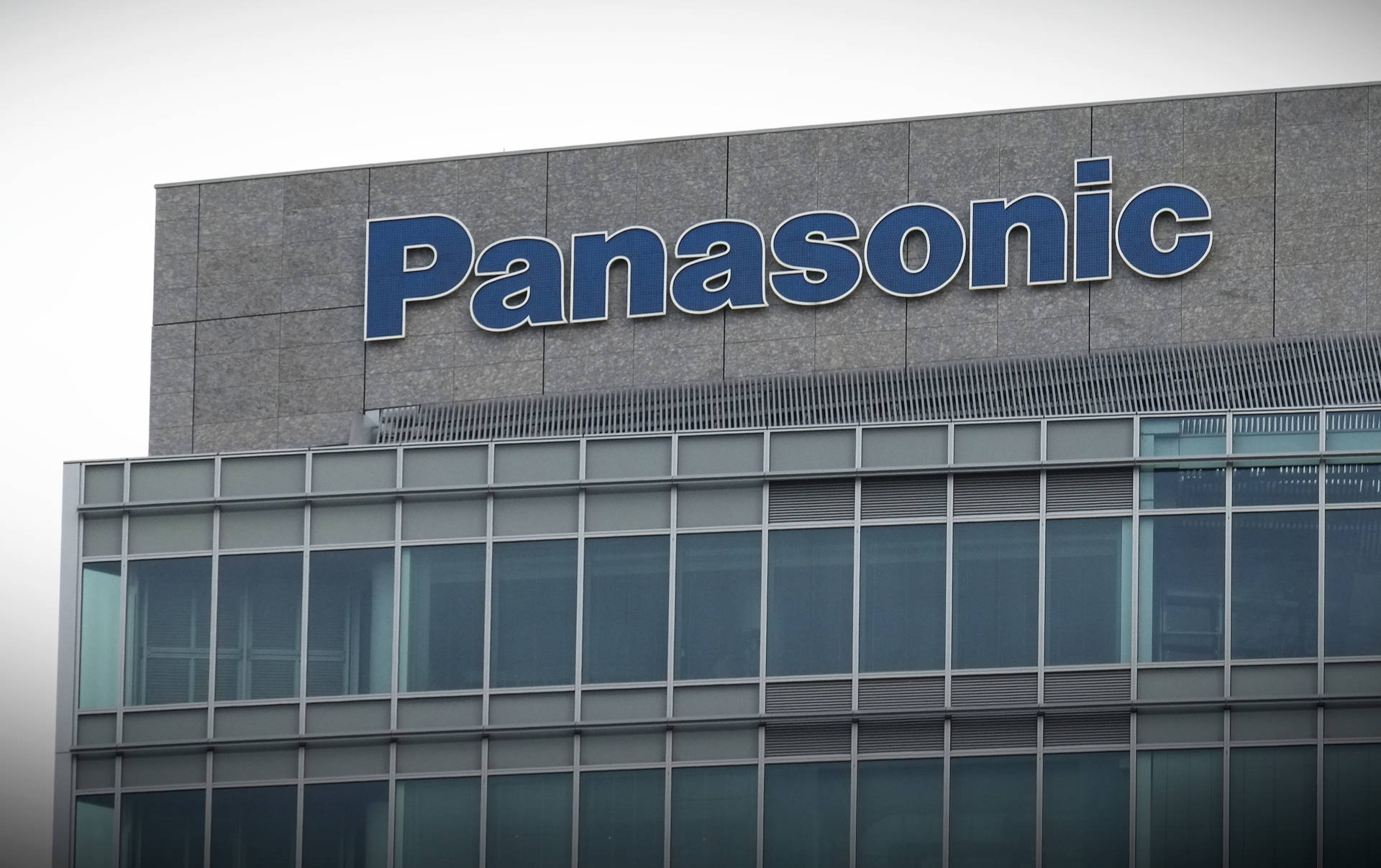Panasonic 企業建築，配有玻璃窗和灰色石牆。