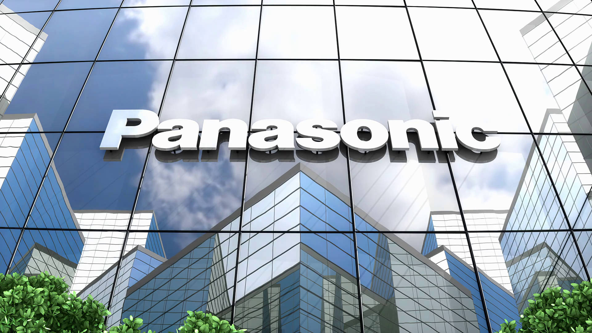 帶有Panasonic標誌的玻璃企業建築，反射天空和雲朵。