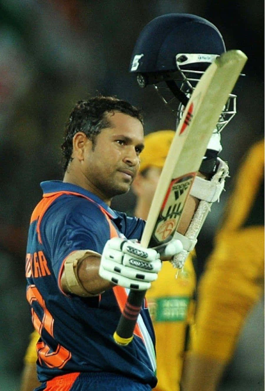 Sachin Tendulkar 桌布 壁紙 — 板球傳奇沙欽·坦杜卡在體育場燈光下的夜間比賽中，以專注的姿勢手持球棒和頭盔。