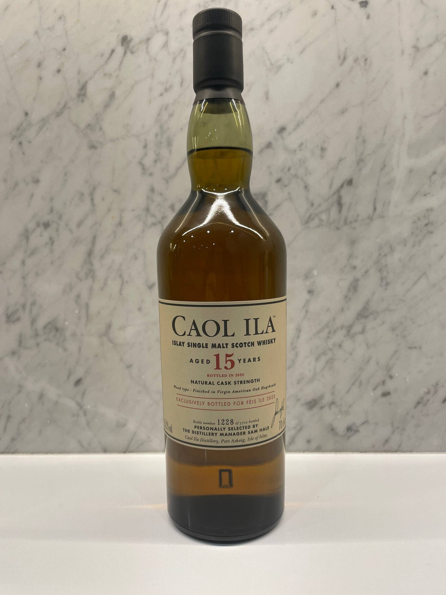 一瓶Caol Ila 15年單一麥芽蘇格蘭威士忌在白色表面上。