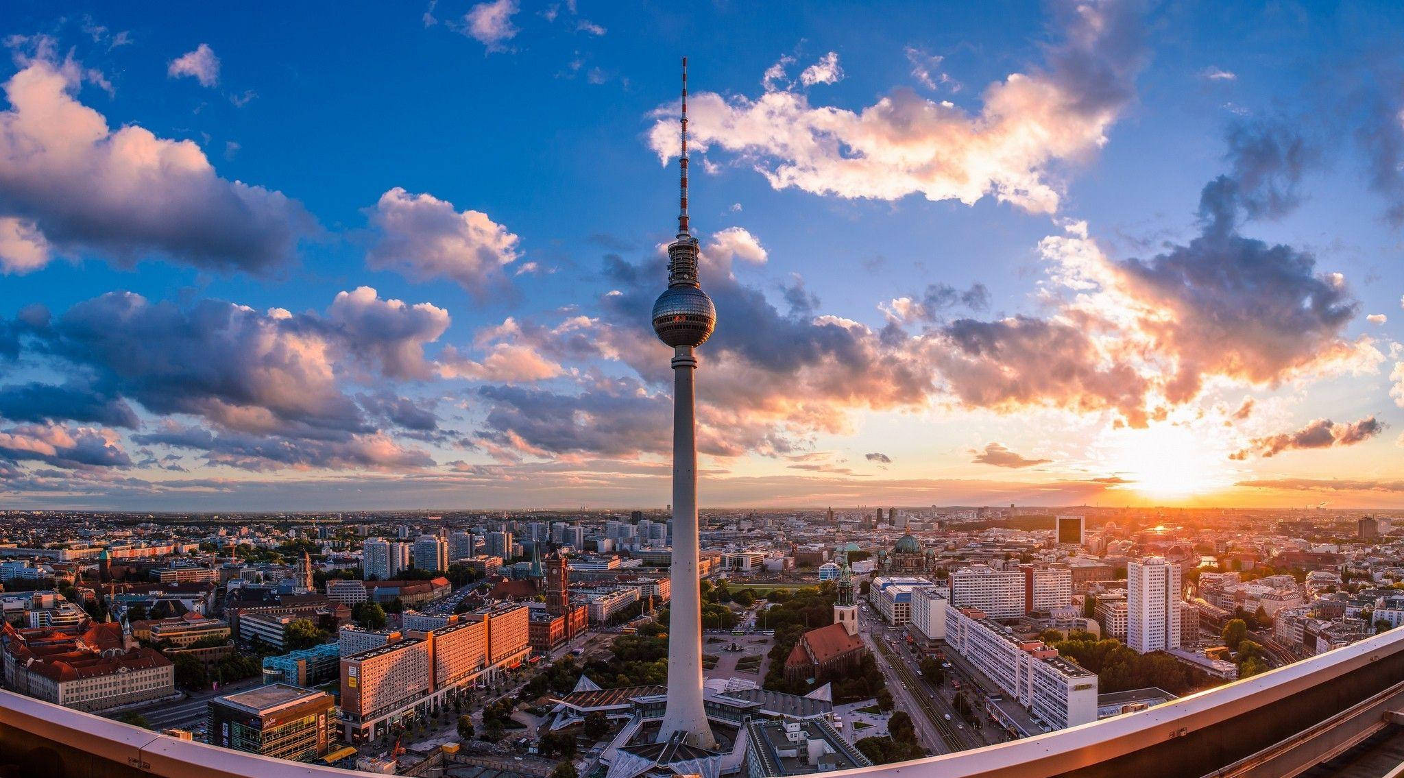 柏林電視塔夕照 壁紙 — 柏林電視塔在戲劇性的日落天空下高聳，金色雲彩覆蓋著廣闊的城市景觀。