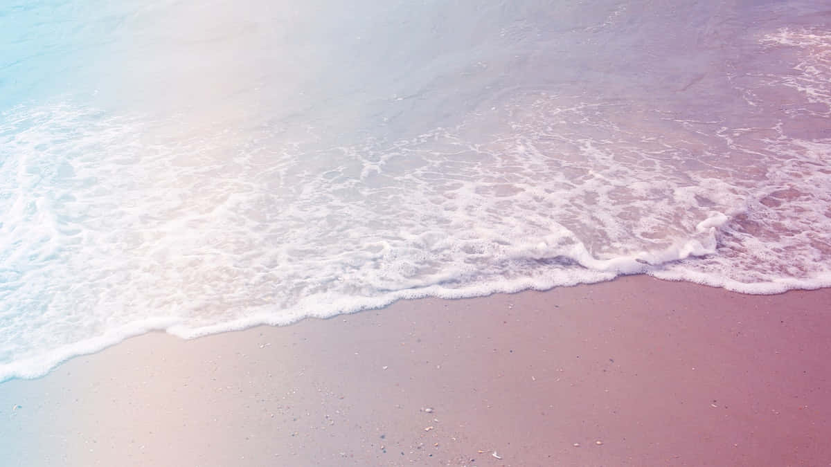Aesthetic Beach 桌布 壁紙 — 柔和嘅粉彩波浪喺朦朧天空下輕輕拍打粉紅色沙灘。