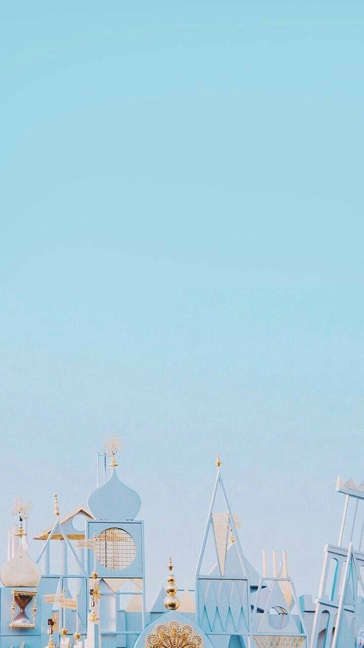 晴朗天空下，帶有金色細節的粉藍色奇幻建築。