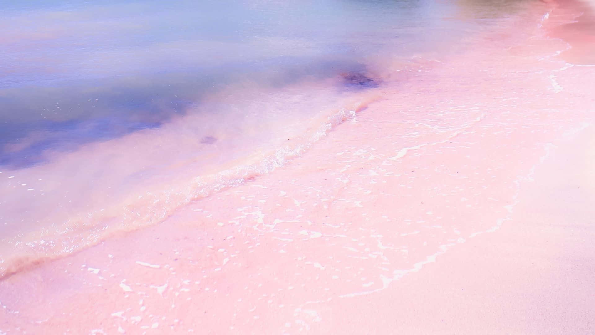 Pink Beach 桌布 壁紙 — 柔和的粉紅色海水輕輕拍打著粉彩色的海岸線，天空是朦朧的藍色。