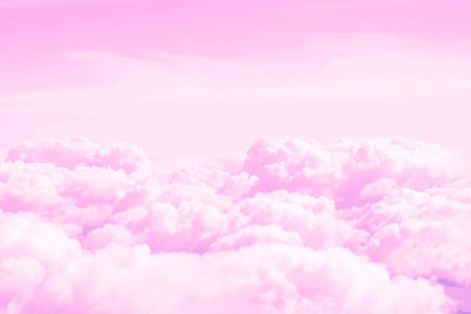Cloud Aesthetic 桌布 壁紙 — 柔和的粉紅雲朵在夢幻般的空中視角中飄過粉彩天空。