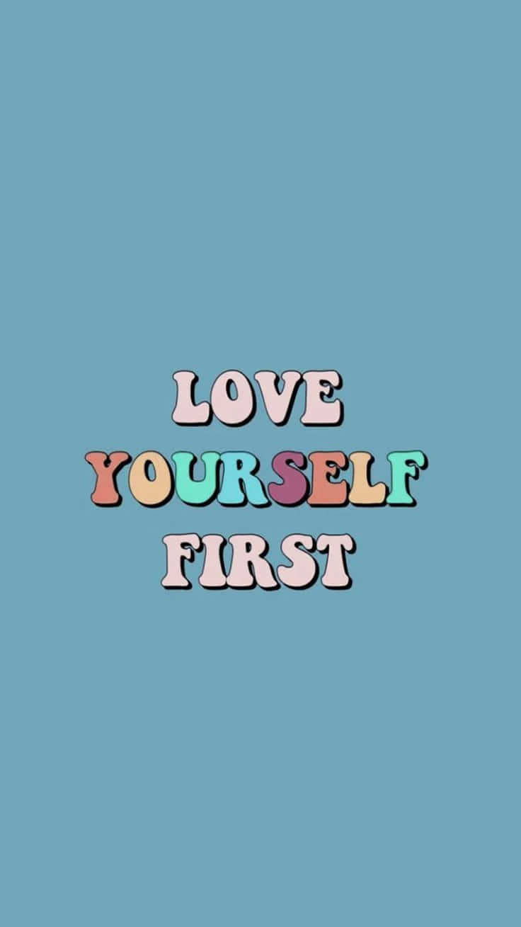 愛戀風格 桌布 壁紙 — 柔和粉彩色調的復古文字「LOVE YOURSELF FIRST」居中顯示在純青色背景上。