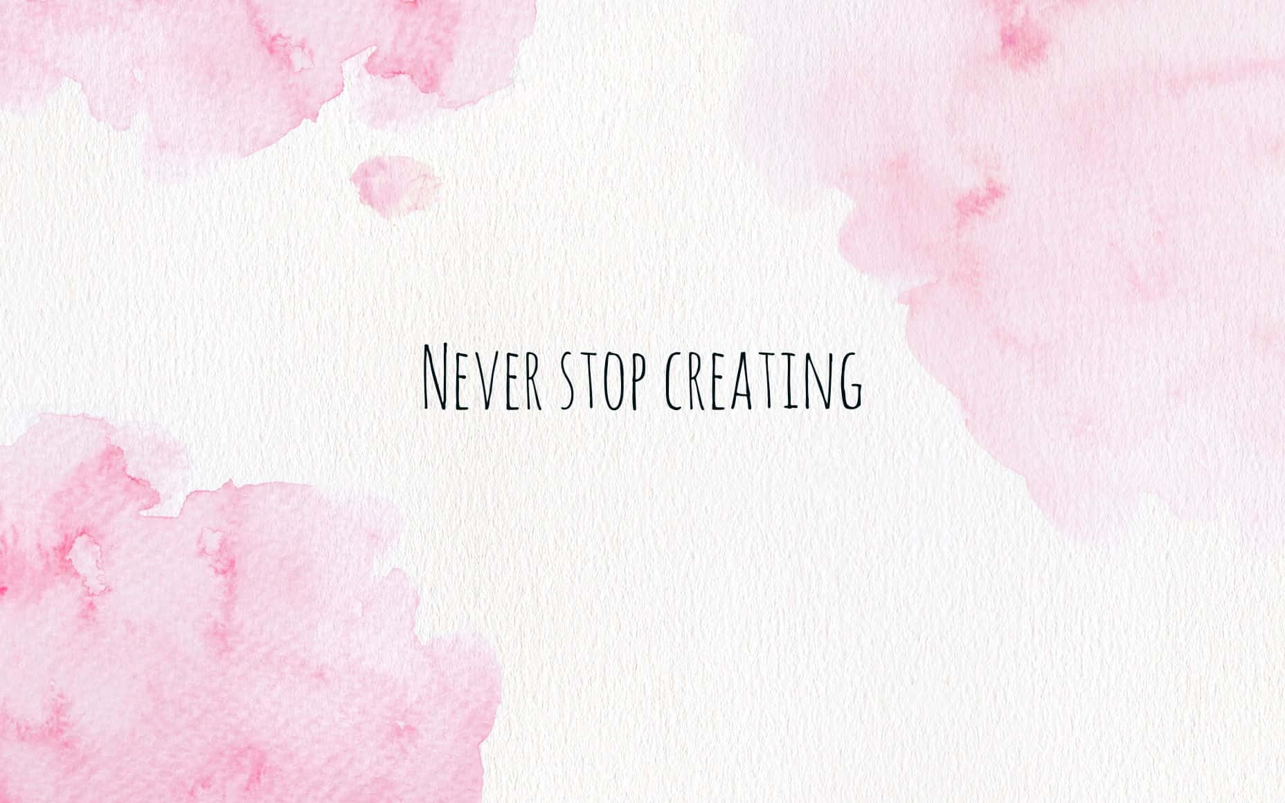 Aesthetic YouTube 桌布 壁紙 — 柔和粉紅色水彩潑濺圍繞著「never stop creating」這句短語，以極簡黑色字體呈現在有紋理的白色紙張上。