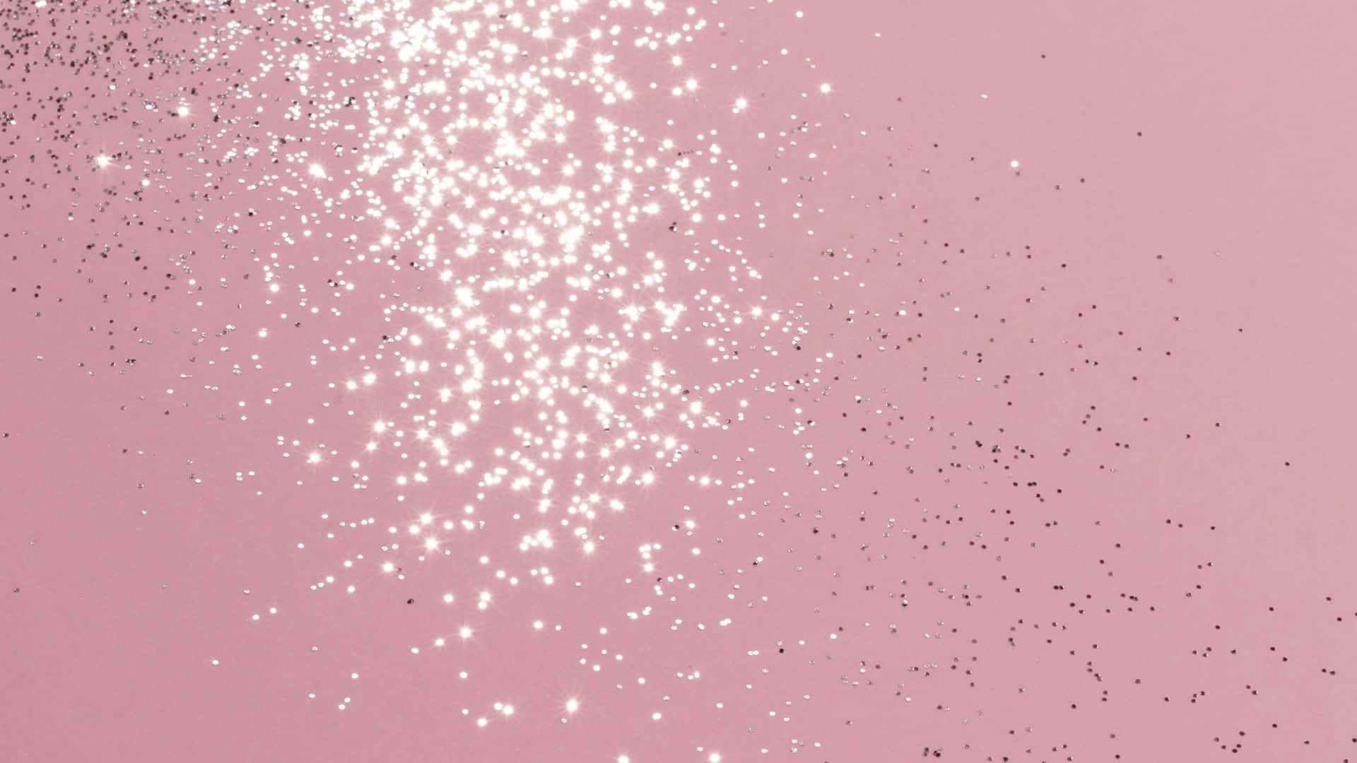 Pink Sparkles 桌布 壁紙 — 柔和粉紅色背景，飾有閃閃發光的白色和黑色閃粉粒子，呈對角線飄散。