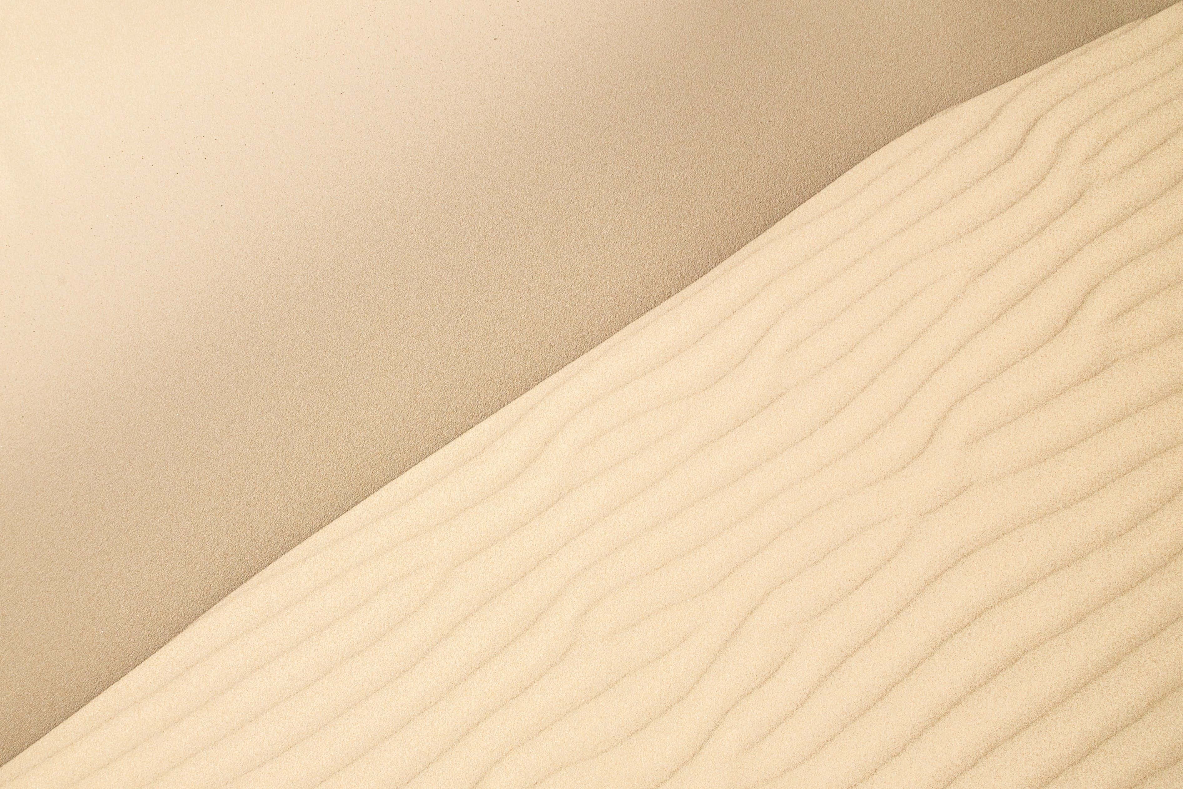 Cream Color 桌布 壁紙 — 柔和自然光下光滑米色沙丘帶有輕微波紋的特寫。