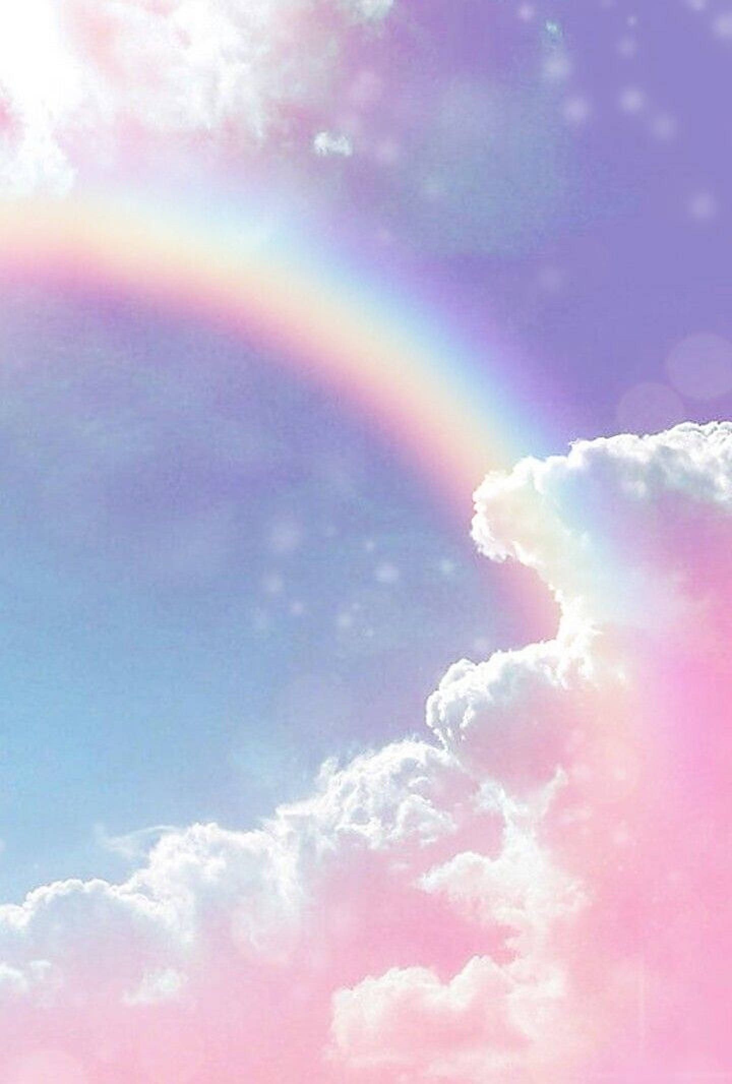 柔彩彩虹與雲朵 壁紙 — 夢幻的粉彩彩虹拱起在蓬鬆的雲朵上，映襯著柔和的藍色和粉紅色天空，帶有散景光效。