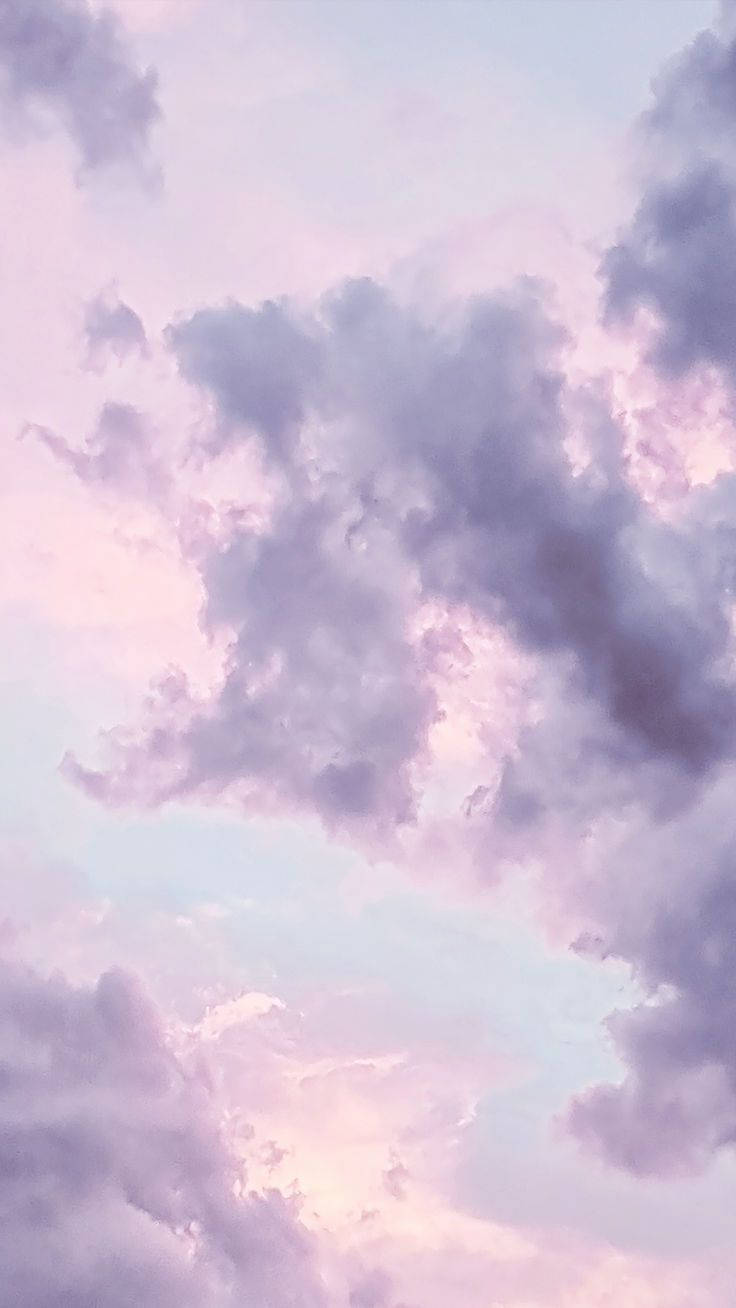 粉彩紫色和粉紅色的雲朵在寧靜的黃昏天空中飄動。