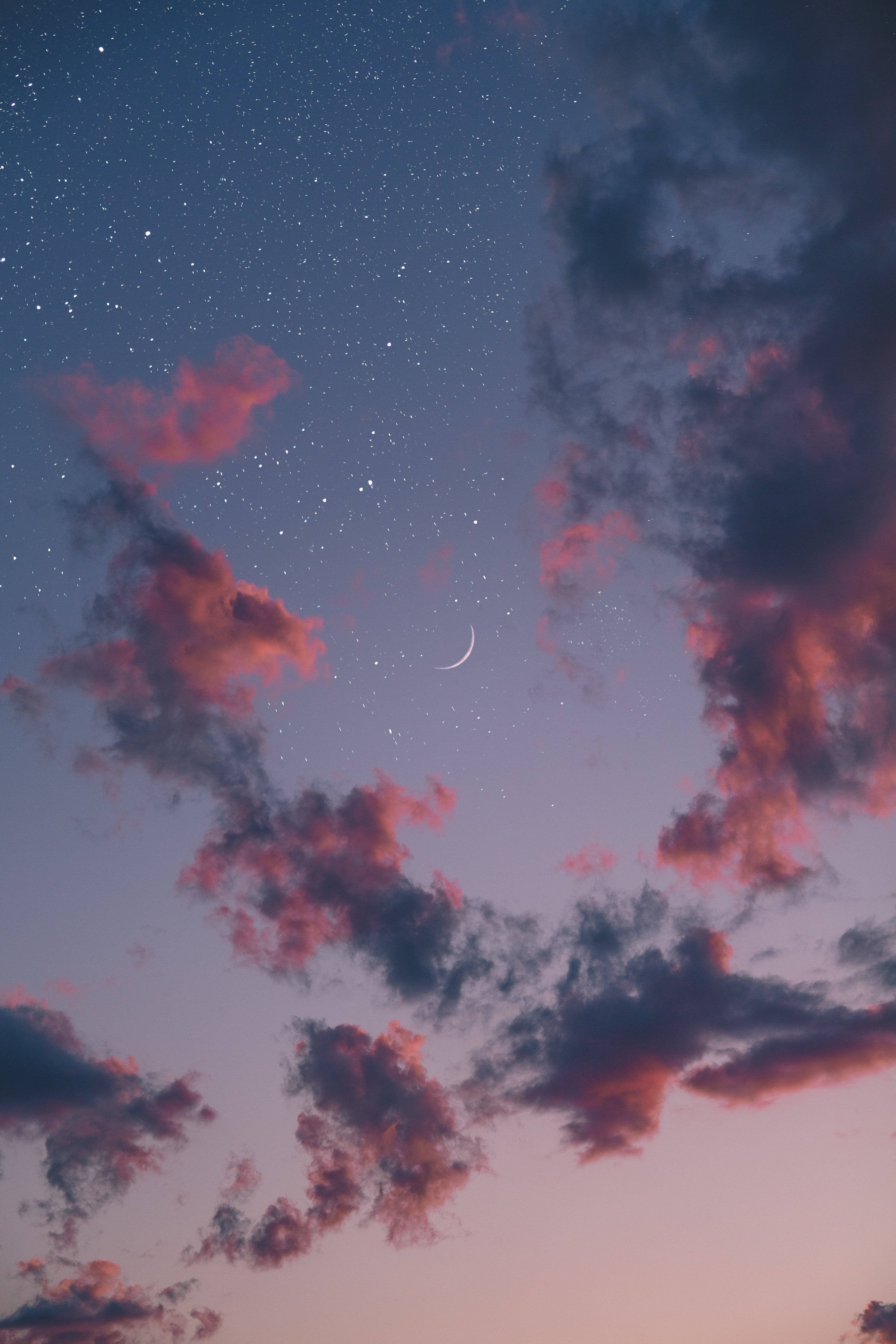 柔美月光 4K 壁紙 — 一彎新月在粉紅色和紫色的雲層上方發光，背景是繁星點點的暮色天空。