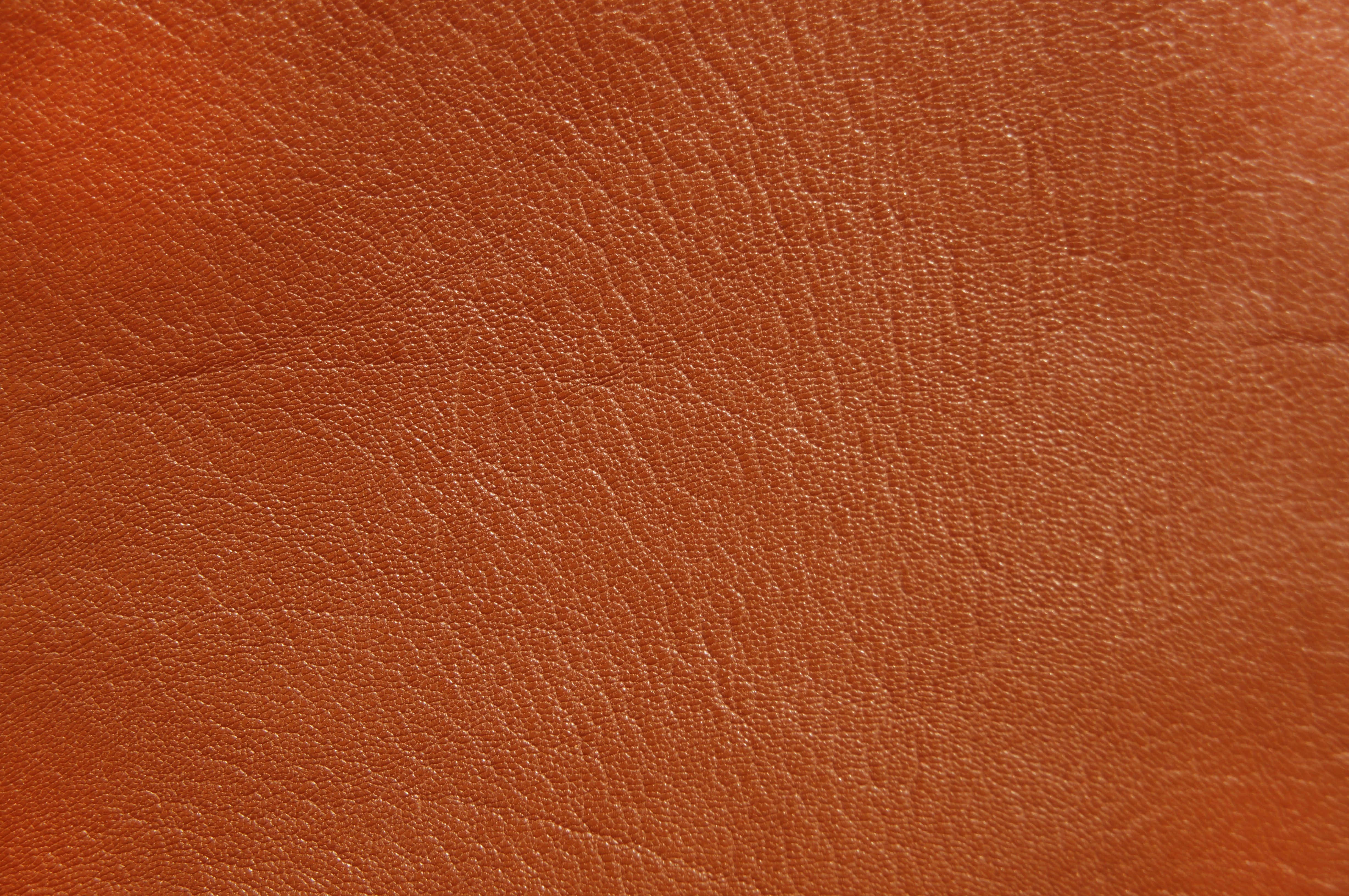Brown Leather 桌布 壁紙 — 柔軟燈光下，天然紋理及細微皺褶的濃郁棕色皮革特寫。