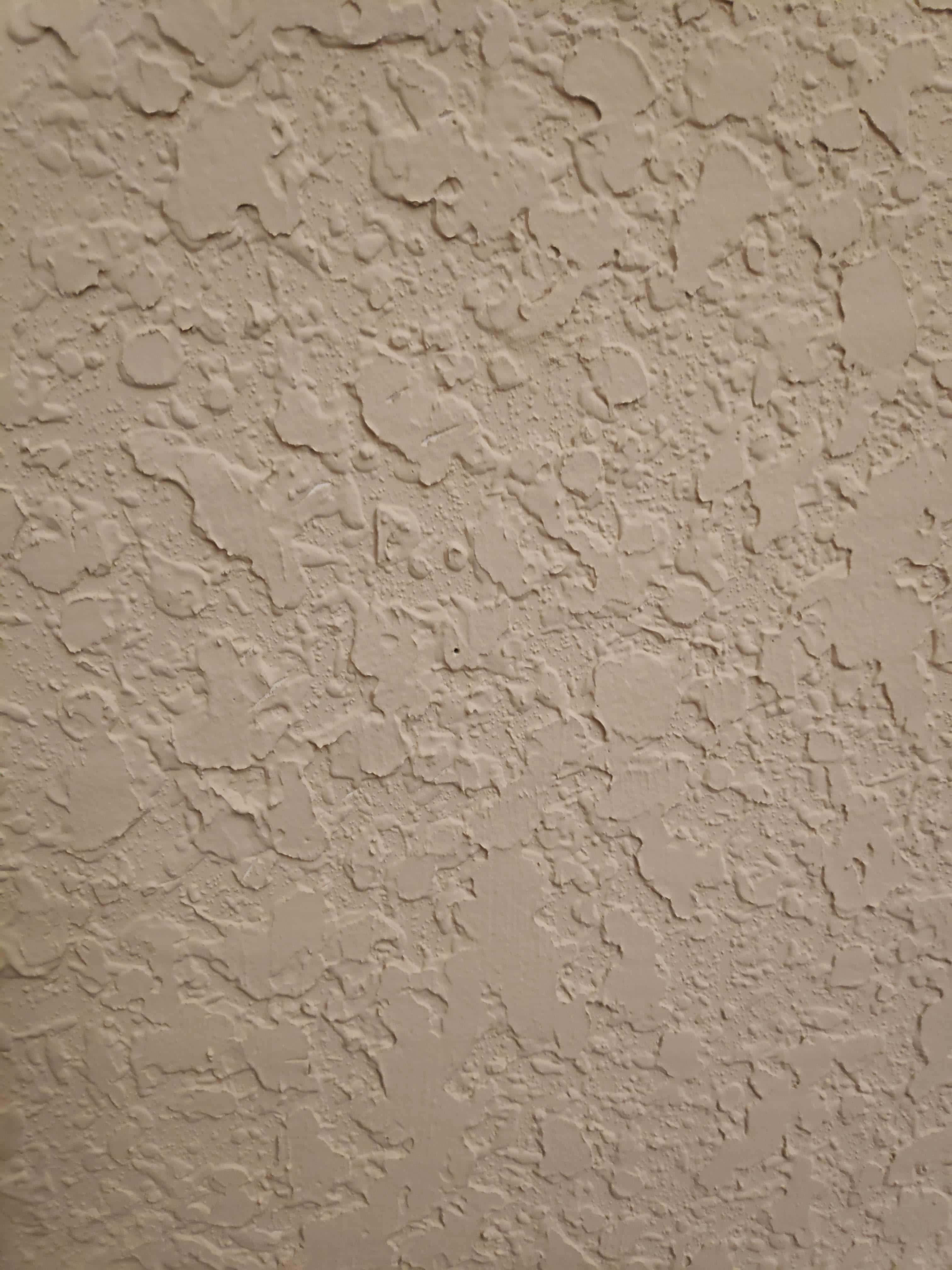 Paint Texture 桌布 壁紙 — 柔軟燈光下嘅米色灰泥牆近鏡，表面粗糙唔平，有細微裂紋。