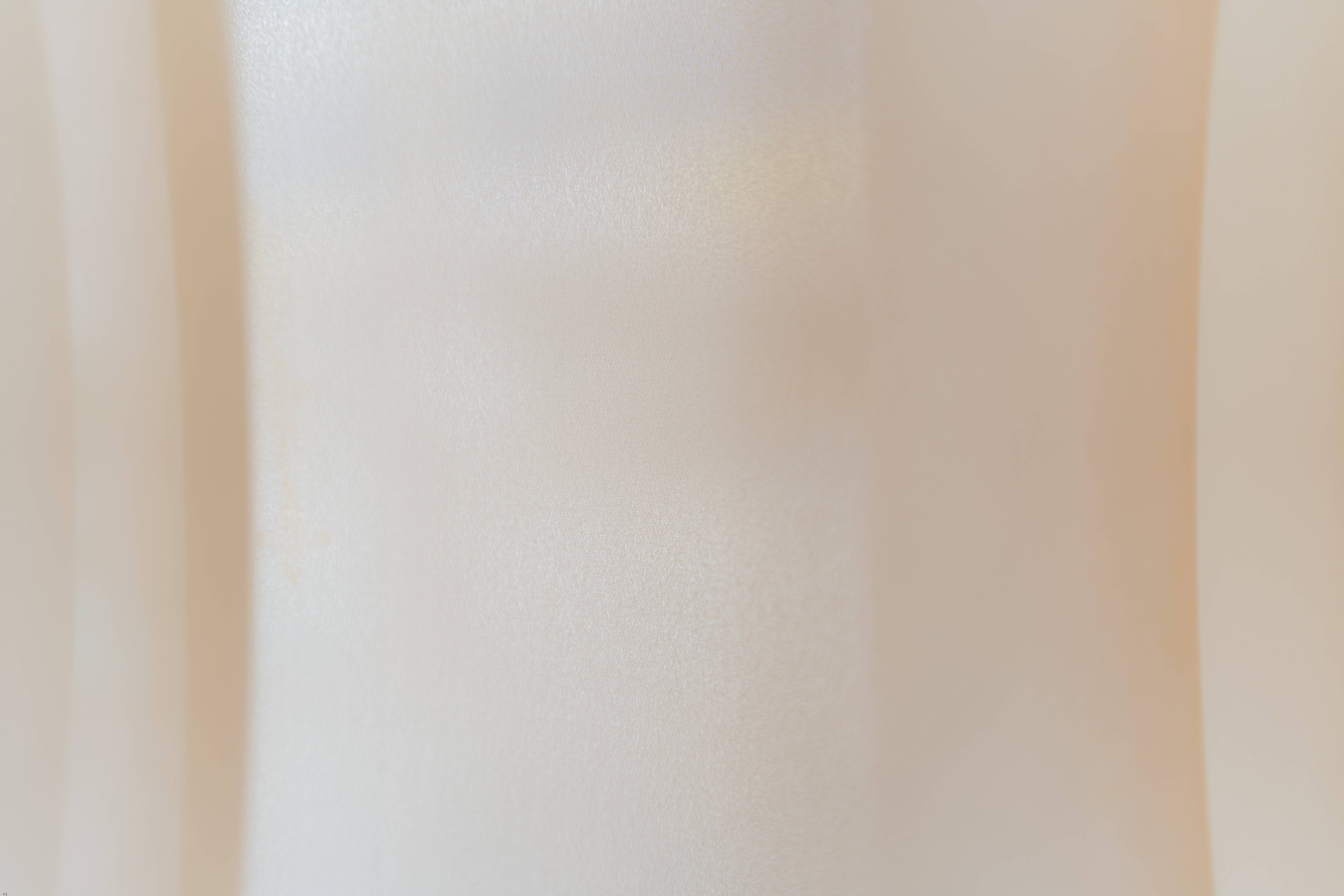 Beige Minimalist 桌布 壁紙 — 柔軟的奶油色布料，帶有柔和皺褶和細微質感，在溫暖環境光下。