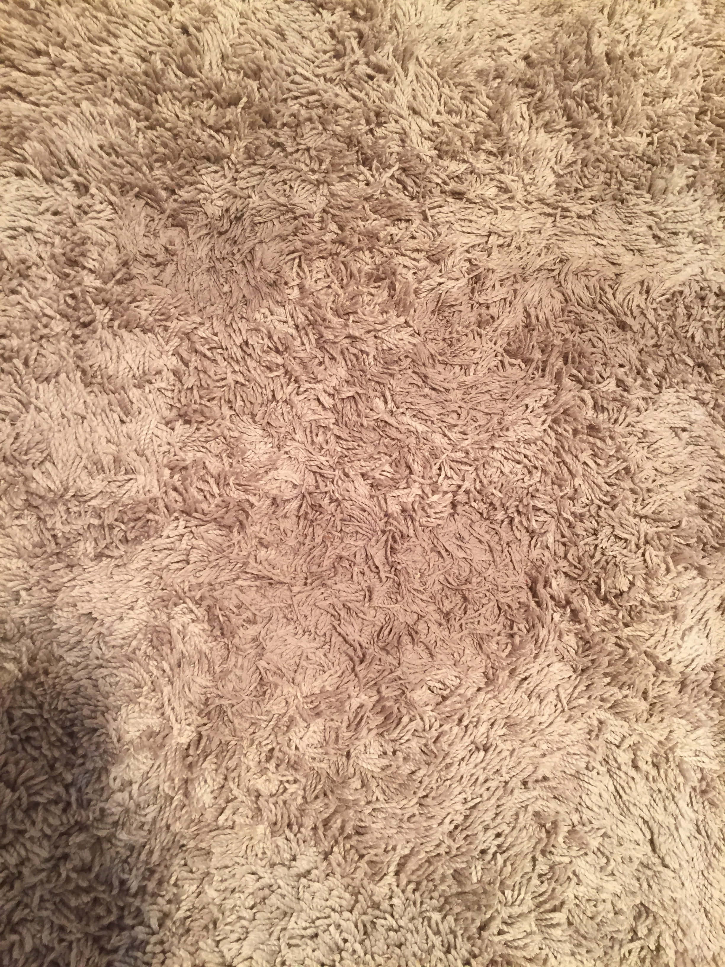 Carpet 桌布 壁紙 — 柔軟米色絨毛地毯的特寫，帶有紋理纖維和來自上方照明的微妙陰影。