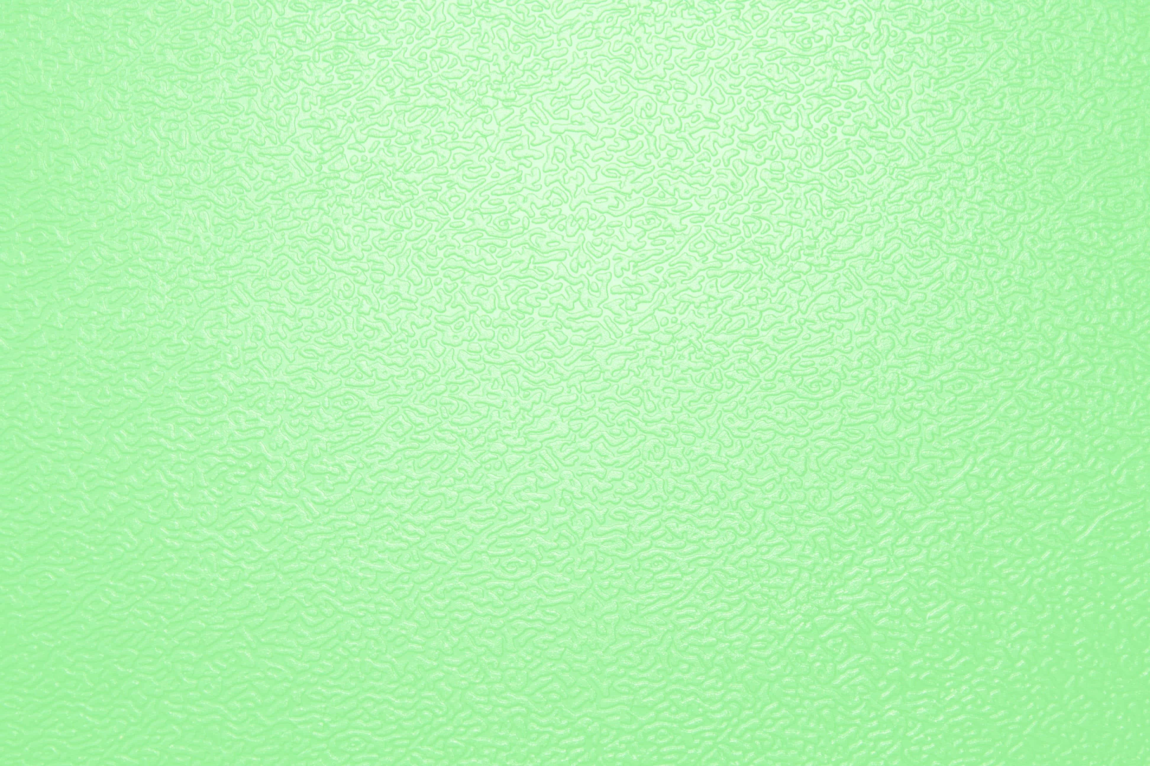 Green Solid Color 桌布 壁紙 — 柔軟薄荷綠色紋理表面，帶有細微波浪圖案，從中心到邊緣呈現柔和漸變。