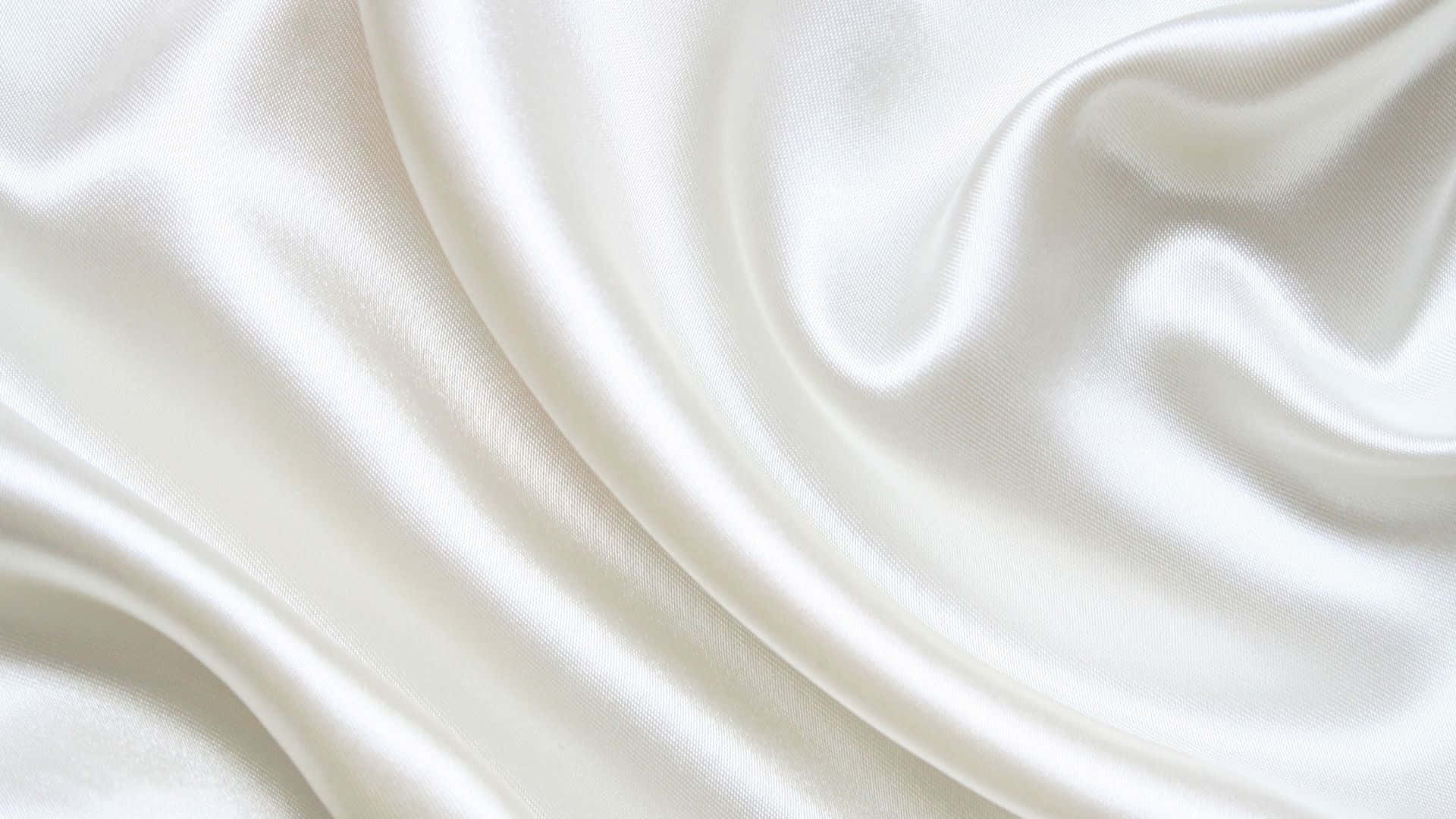 柔軟質感白色絲綢背景 壁紙 — 光滑的白色絲綢布料以柔和的波浪流動，帶有柔和的高光和陰影。