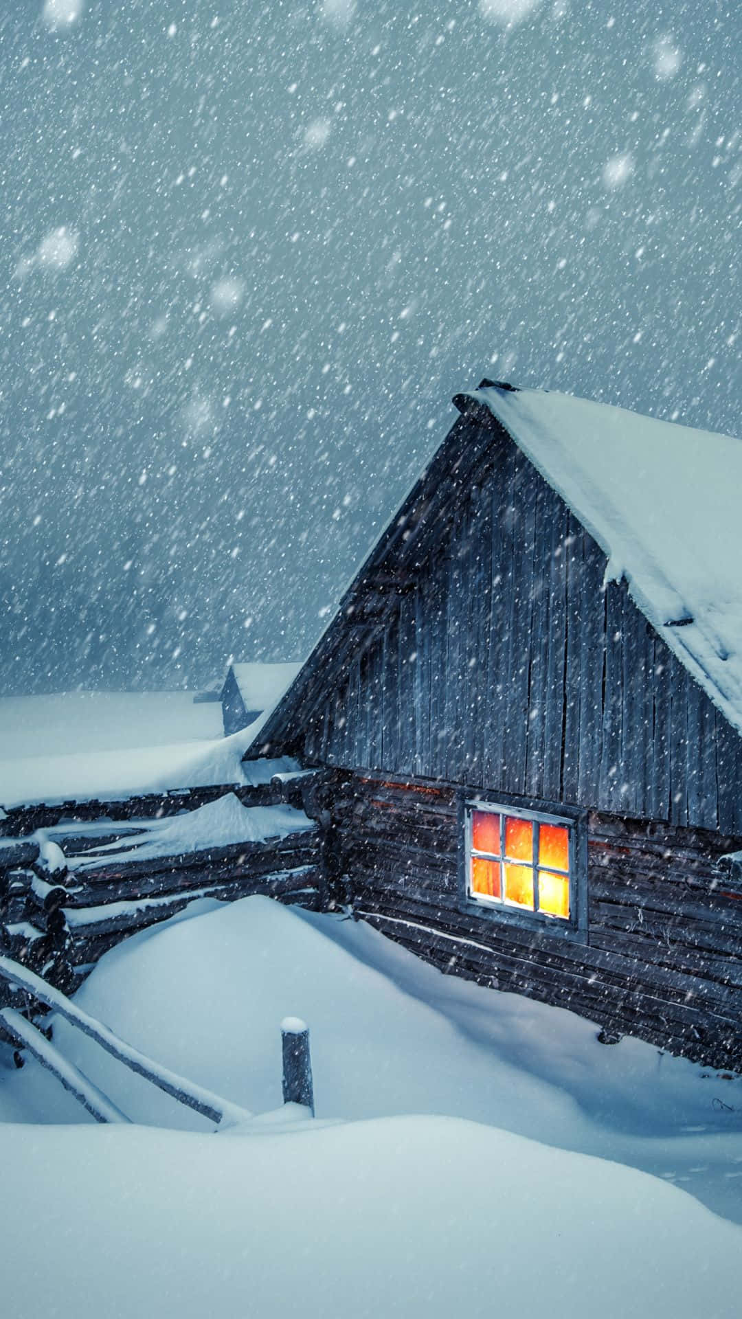 被雪覆蓋的小屋，在冬季風暴中窗戶發光