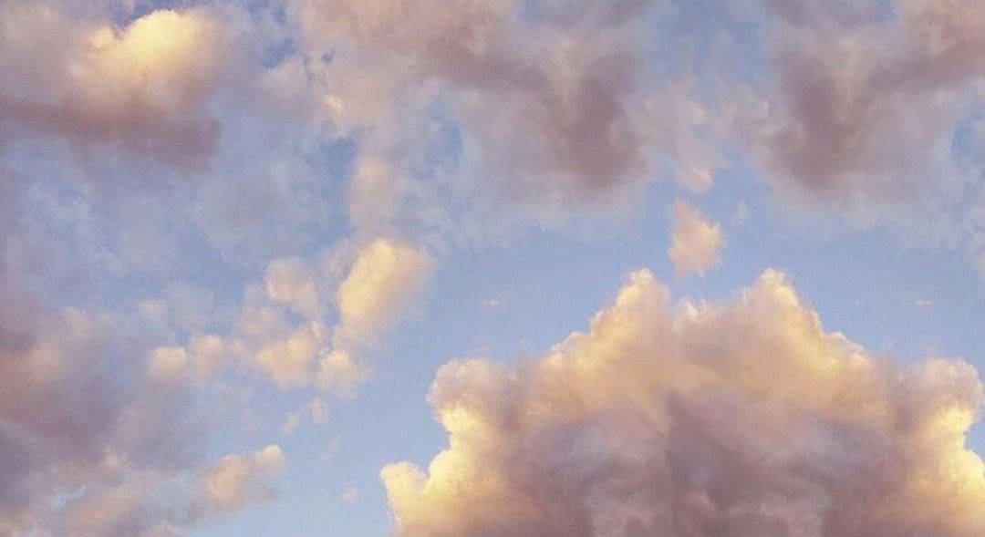 柔軟雲朵桌面 壁紙 — 柔和嘅粉彩雲喺日落時分飄過一片寧靜嘅天空，散發住溫暖嘅金色同薰衣草色調。