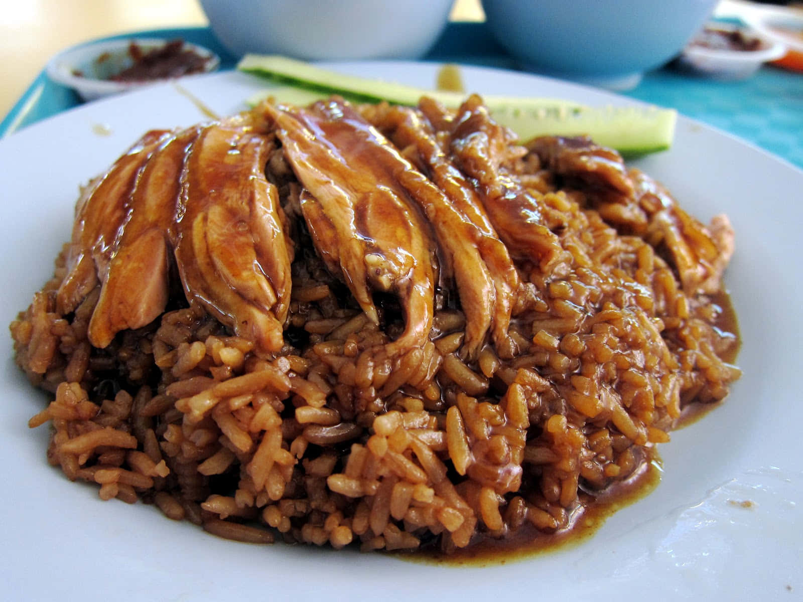 查基無骨滷鴨攤位招牌鴨肉飯 壁紙 — 白碟上嘅特寫：油亮燜雞配鹹香糙米飯同青瓜片。