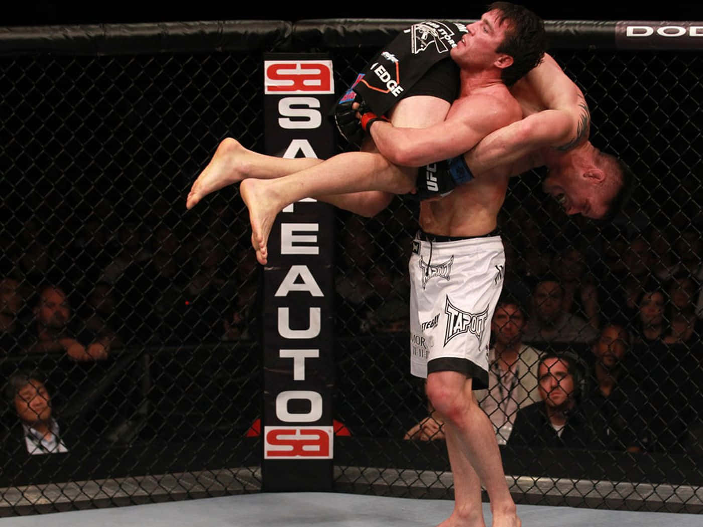 兩名MMA拳手在八角籠內進行纏鬥比賽。