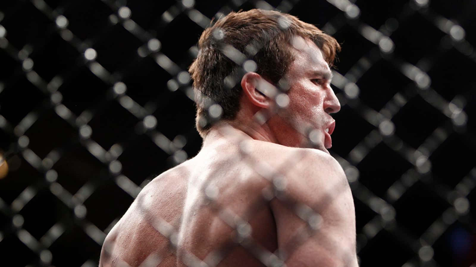 一個赤裸上身的戰士在MMA八角籠中展現高度專注。