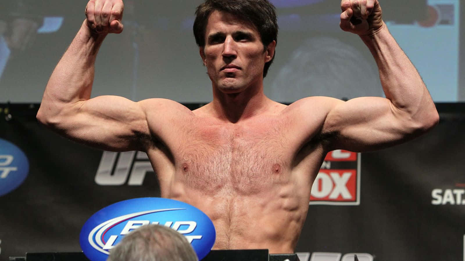一名肌肉發達的男性拳手在稱重時於UFC磅秤上彎曲手臂。