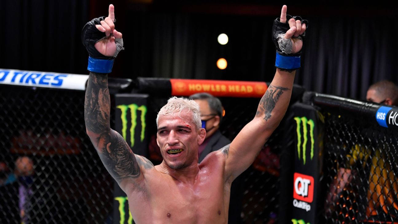 MMA 拳手在八角籠內高舉雙拳慶祝勝利。