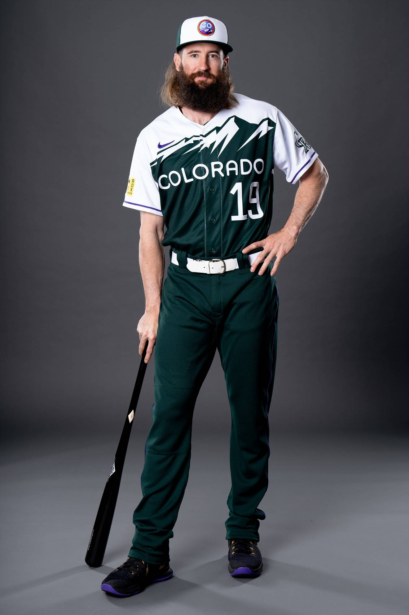 查理·布萊克蒙穿綠色球衣 壁紙 — 留鬍鬚嘅棒球手著住科羅拉多洛磯隊制服，喺灰色影樓背景前自信地擺姿勢揸住球棒。
