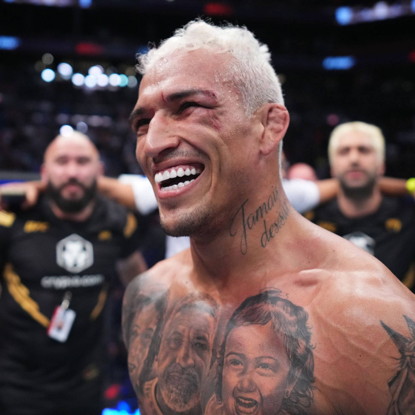 有紋身的MMA拳手在八角籠中慶祝勝利。