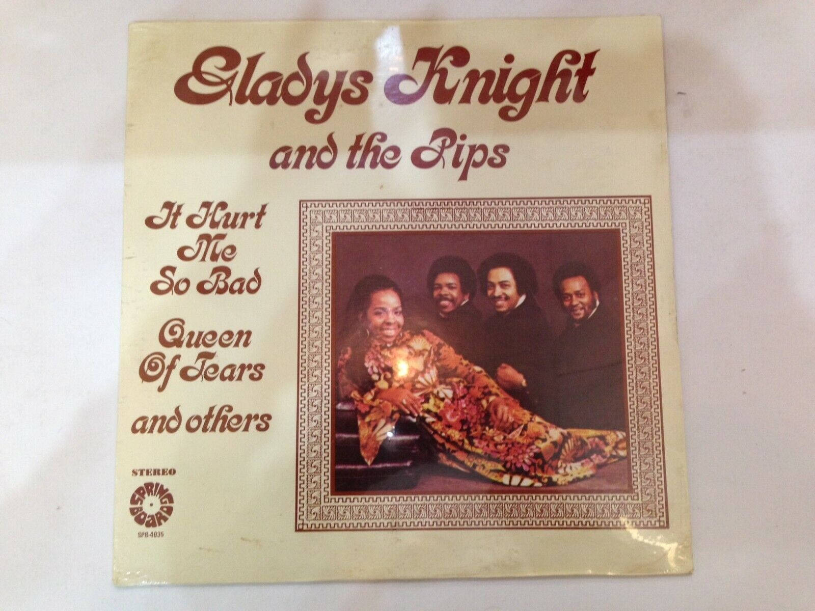 格拉迪斯·奈特與合唱團黑膠唱片 壁紙 — Gladys Knight and the Pips 的復古黑膠唱片專輯封面，以溫暖燈光的肖像、華麗邊框和粗體紅色字體呈現。