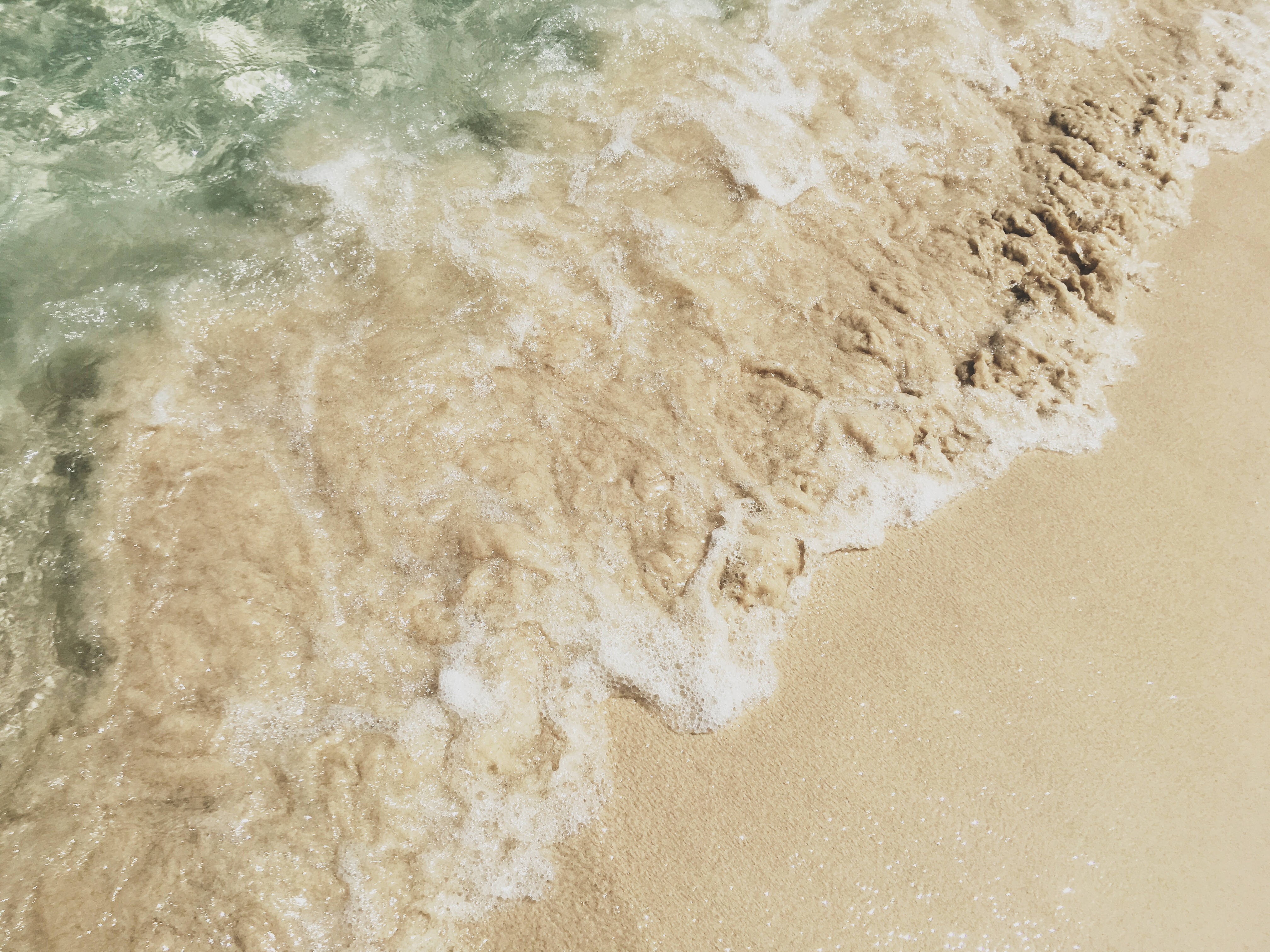 格林納達海灘浪花 壁紙 — 海洋波浪輕輕拍打金色沙灘，泛起白色泡沫的近距離特寫。
