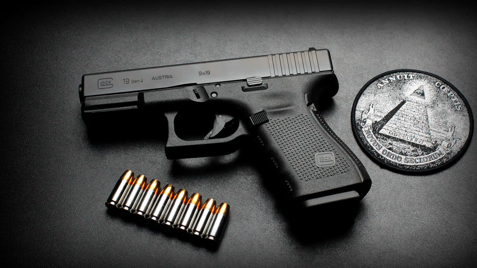 格洛克19——可靠且精準的半自動手槍 壁紙 — 一把黑色Glock 19手槍、九發9x19mm子彈和一枚共濟會硬幣放在深色紋理表面上，在戲劇性的燈光下。